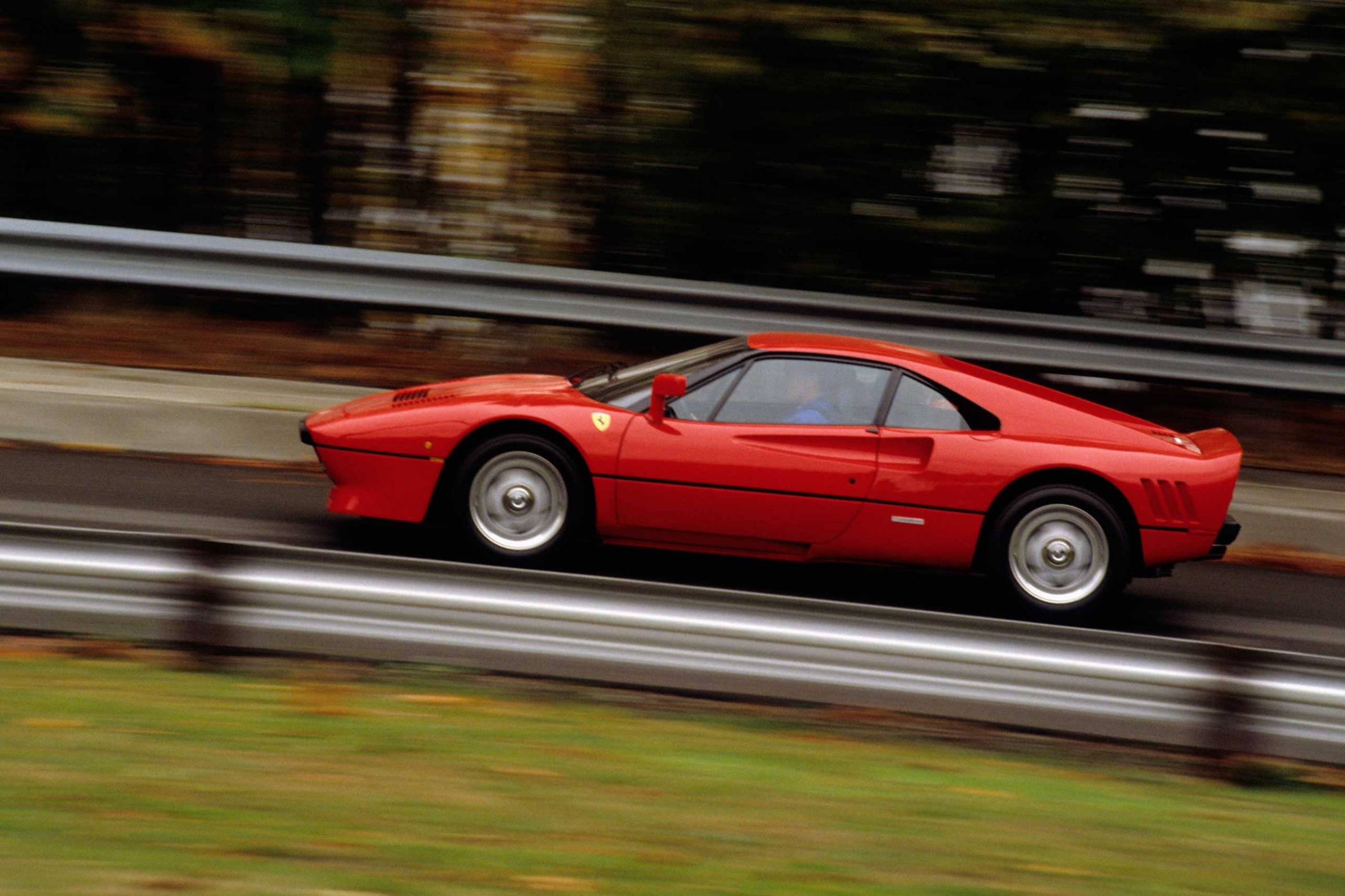 1986 Red Ferrari 288 GTO in speed on road, side view