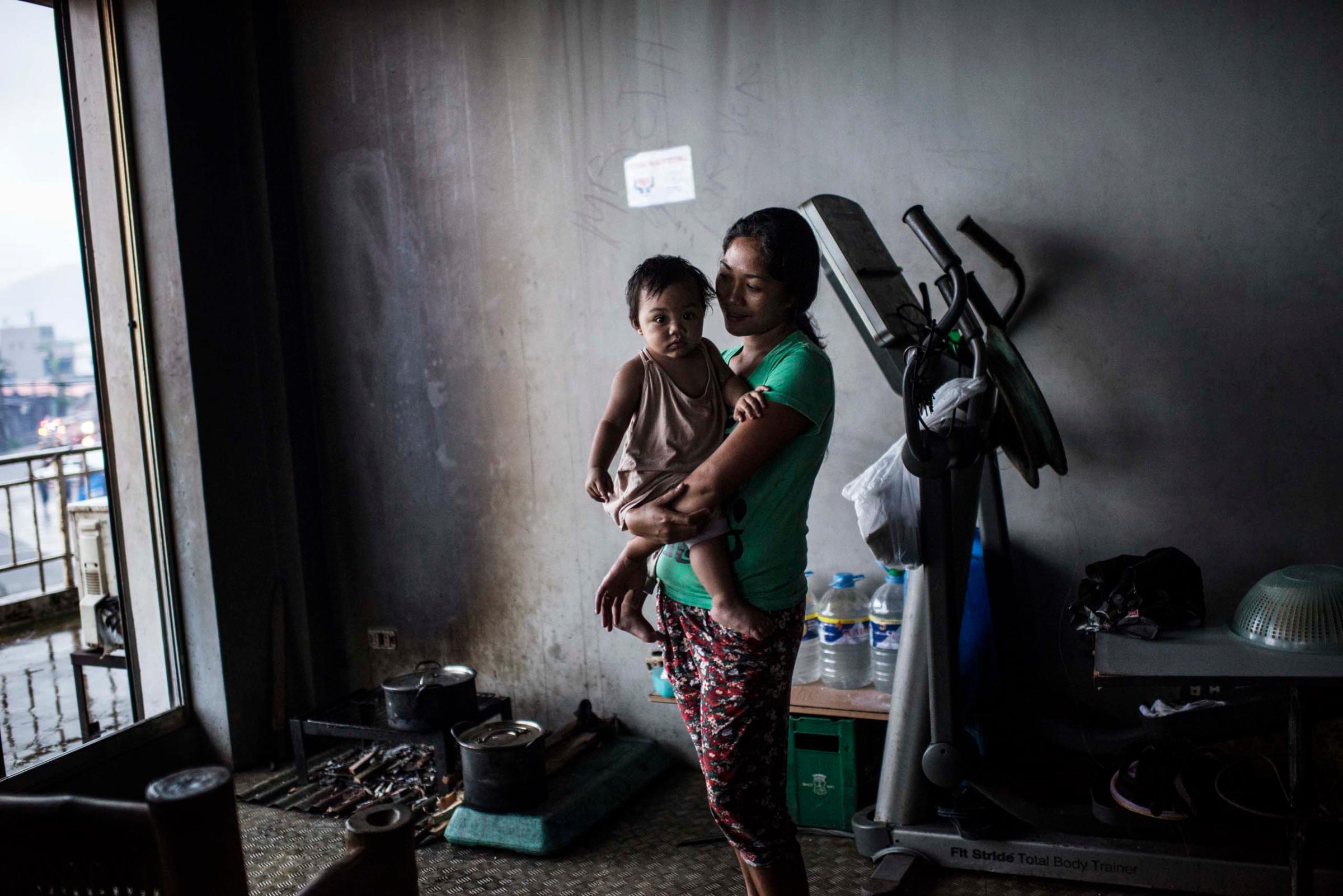 Jan.13, 2014: Displaced Philippine mother and child living inside the former gym in the stadium in Tacloban.