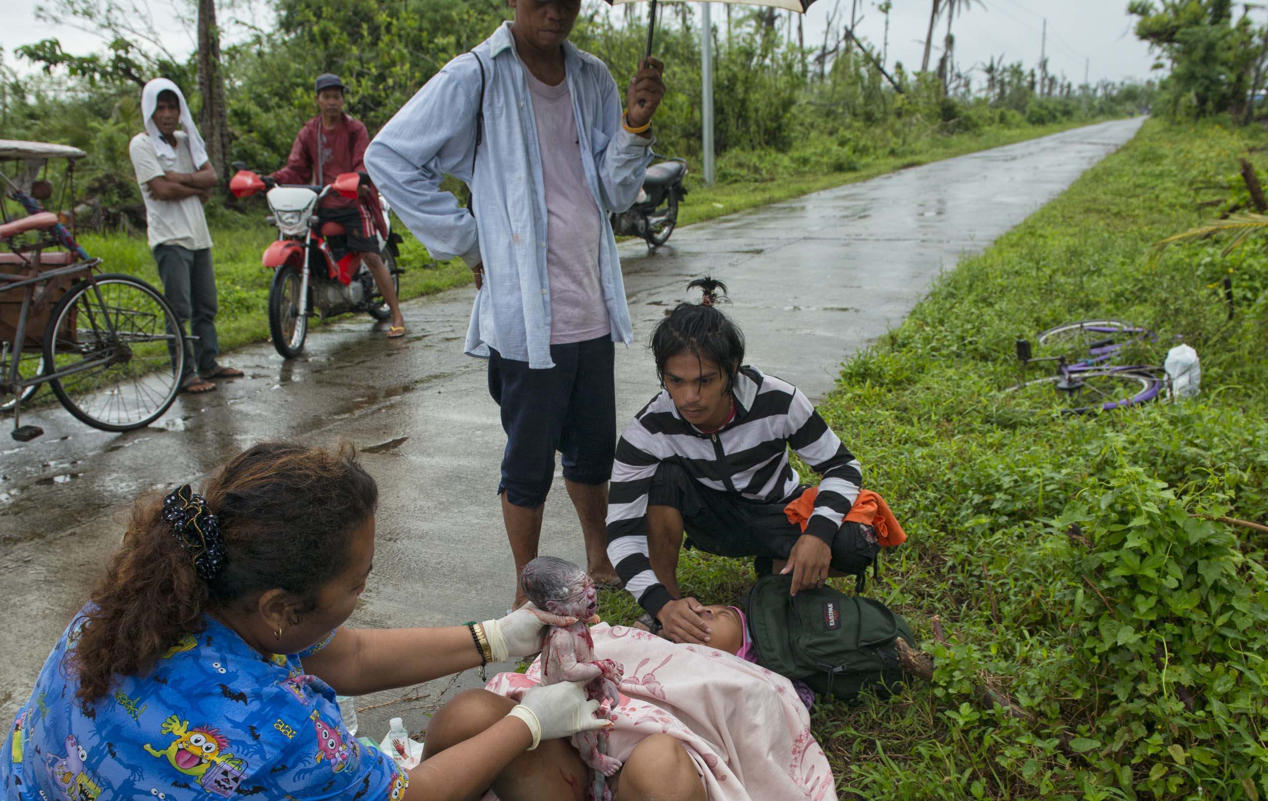 Jan. 11, 2014:  Analyn Pesado, 18, gives birth on  the side of the road en route to the nearest clinic in Tolosa, outside of Tacloban.