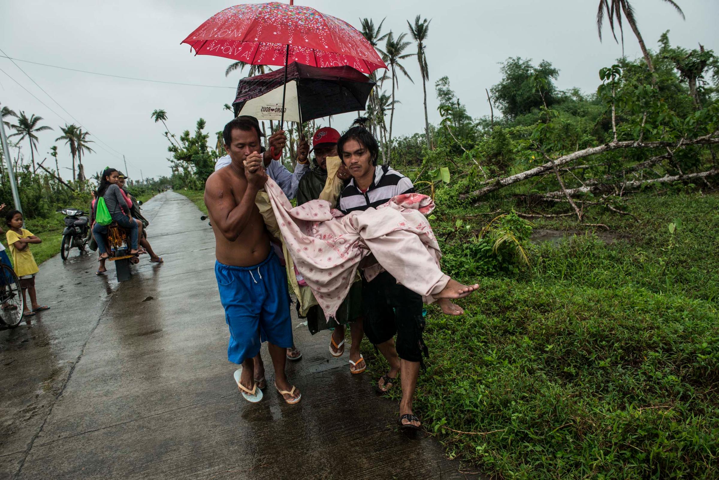 Jan.11, 2014: After the baby is born, Bacate and passersby help carry Analyn Pesado and the baby to a pickup truck on the road outside of Tacloban.