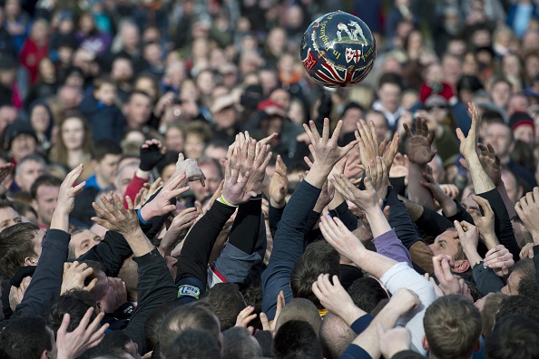 Opposing teams of the Up'ards and the Down'ards reach for the ball as they compete in the annual Royal Shrovetide Football Match in Ashbourne, Derbyshire, England on February 17, 2015.