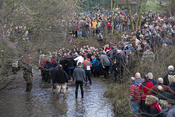 Opposing teams of the Up'ards and the Down'ards stand in water as they compete in the annual Royal Shrovetide Football Match in Ashbourne, Derbyshire, England on February 17, 2015. (Oli Scarff—AFP/Getty Images)