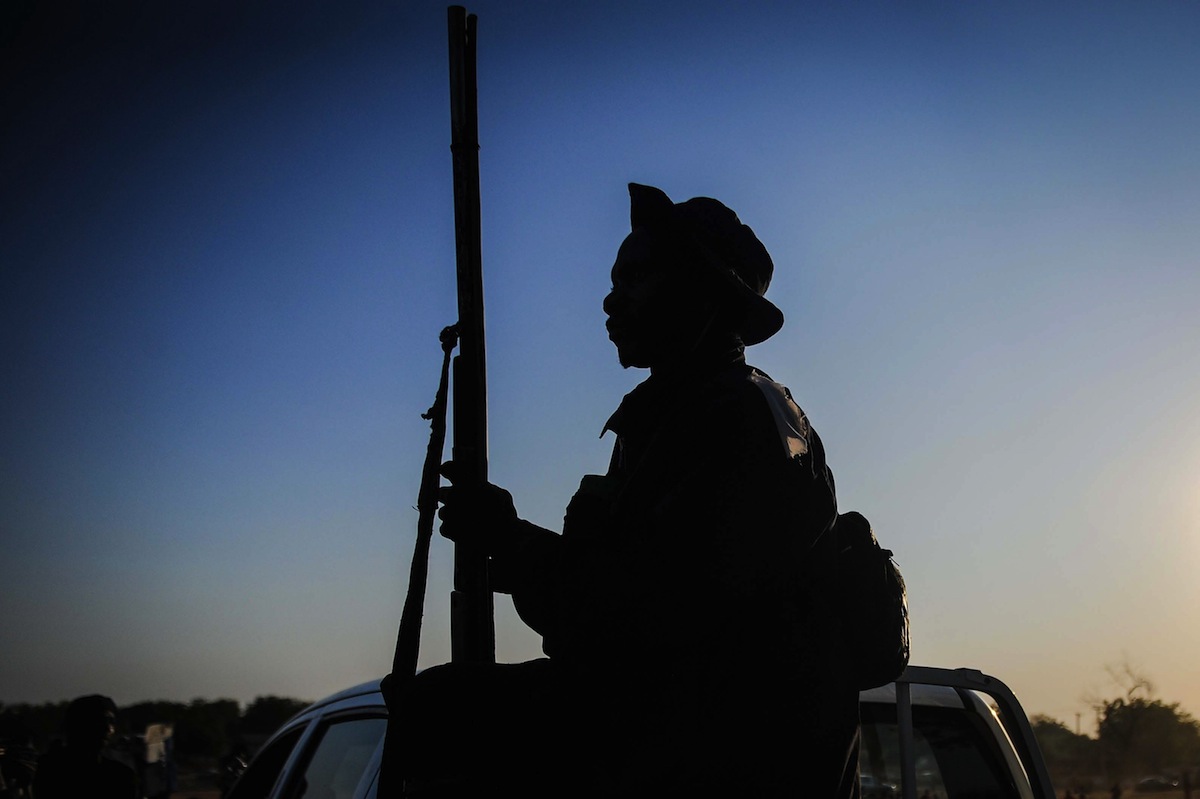 A local hunter armed with a gun is seen on a pick up truck in Yola city of Adamawa State in Nigeria before he moves to the border region between Nigeria and Cameroon to support the Nigerian army in fighting with Boko Haram militants on Dec. 06, 2014. (Anadolu Agency—Getty Images)