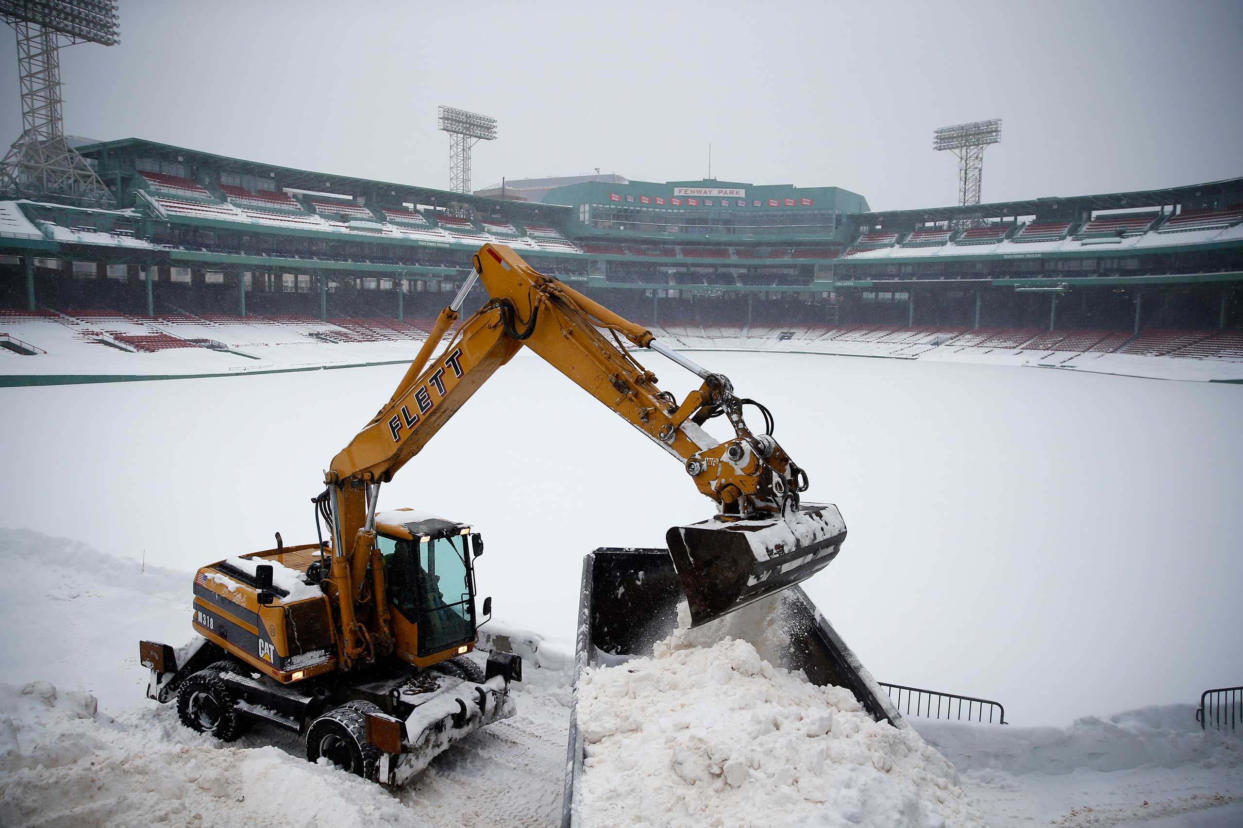 A piece of heavy equipment is used to clear snow from the warning track at Fenway Park in Boston on Feb. 9, 2015.