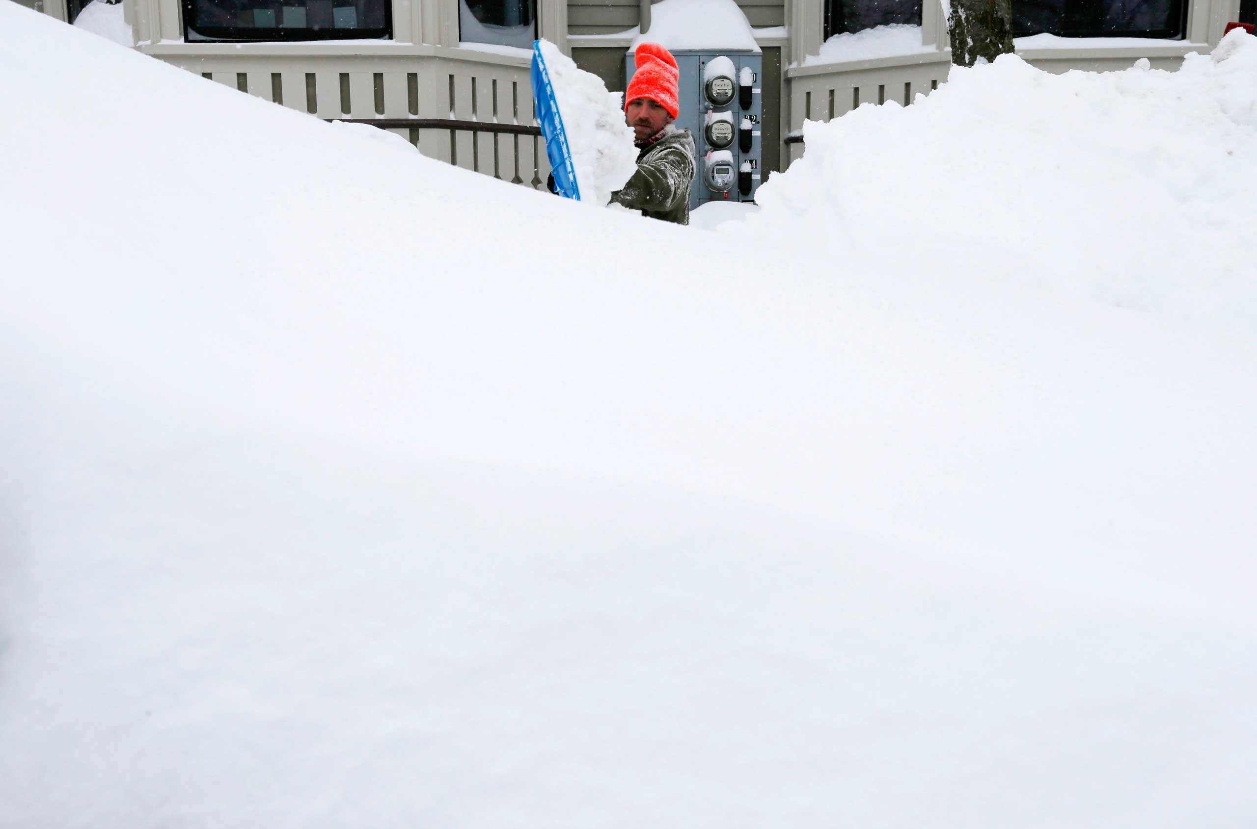 Greg Burkett clears the snow from the front of his house during a winter snowstorm in Cambridge, Mass. on Feb. 9, 2015.