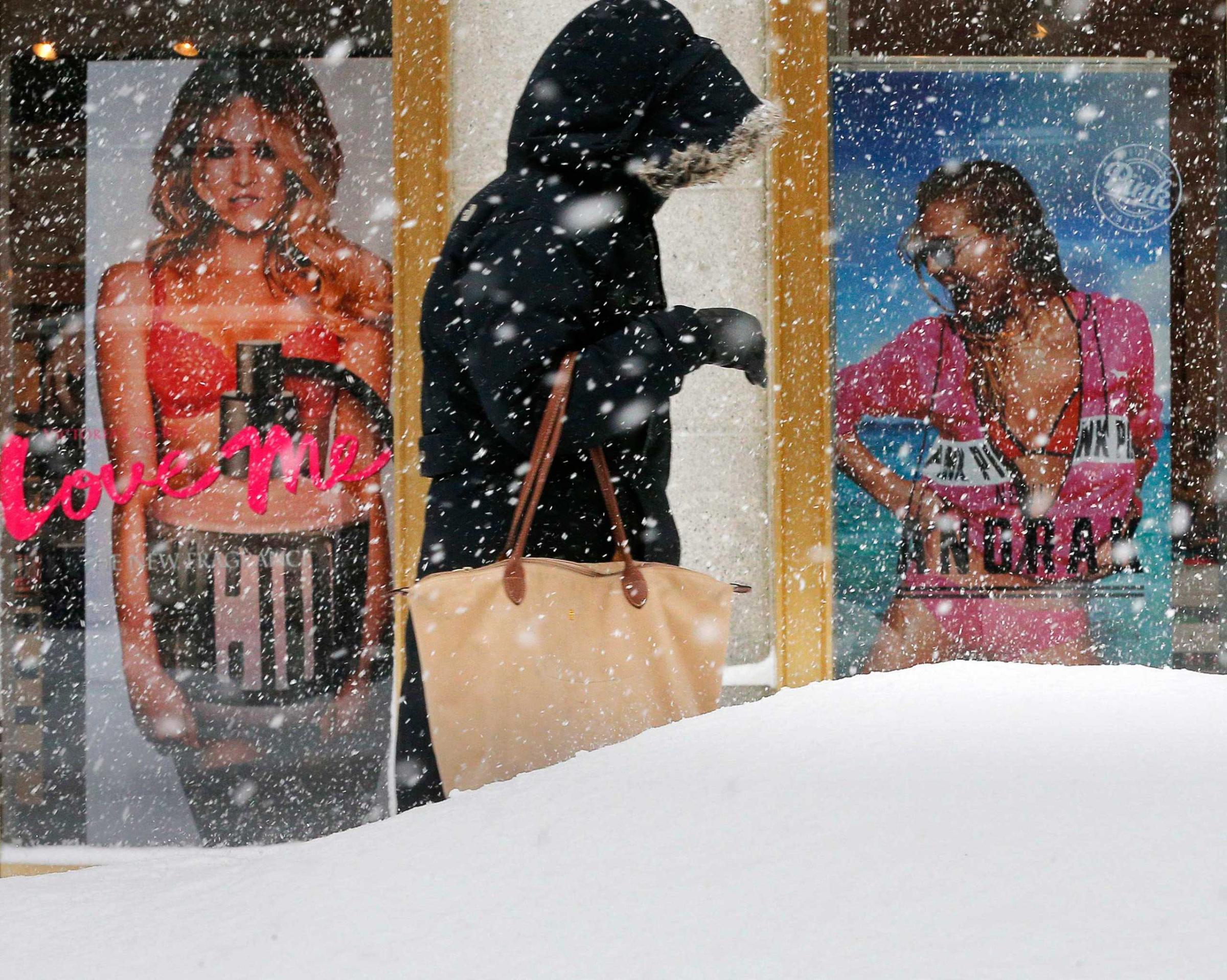 A pedestrian makes their way past a Victoria's Secret store along a snow covered street during a winter snowstorm in Boston