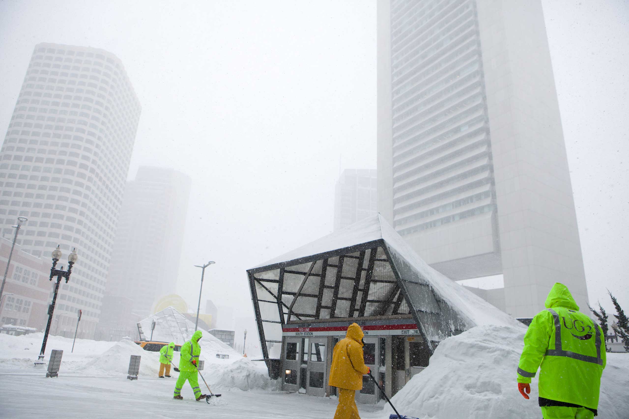 Workers clear snow around the Massachusetts Bay Transportation Authority's (MBTA) South Station in Boston on Feb. 9, 2015.