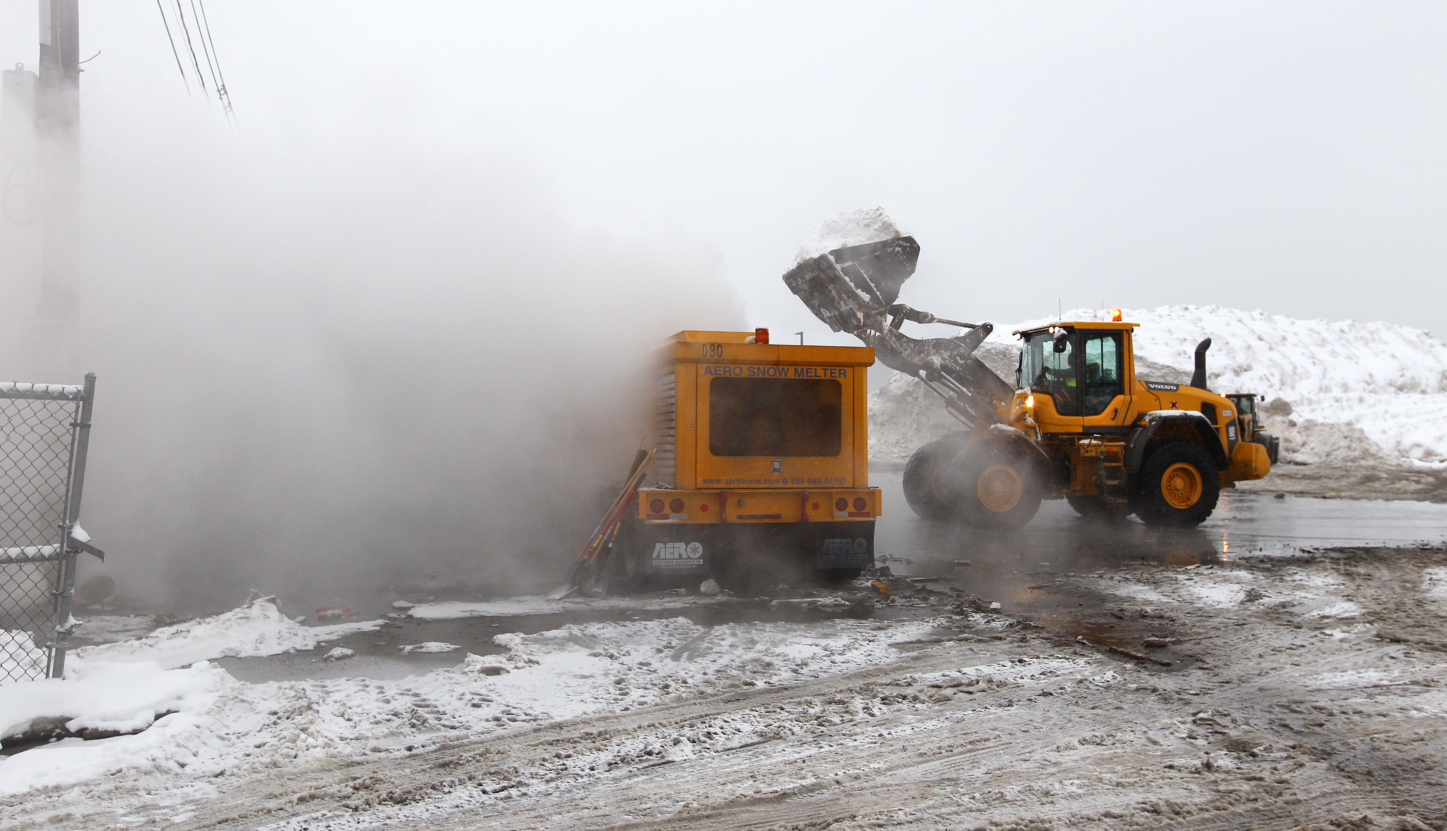 Crews use an Aero Snow Melter to dispatch mounds of snow at the Marine Industrial Park snow farm on Feb. 8, 2015. (Pat Greenhouse—Boston Globe/Getty Images)