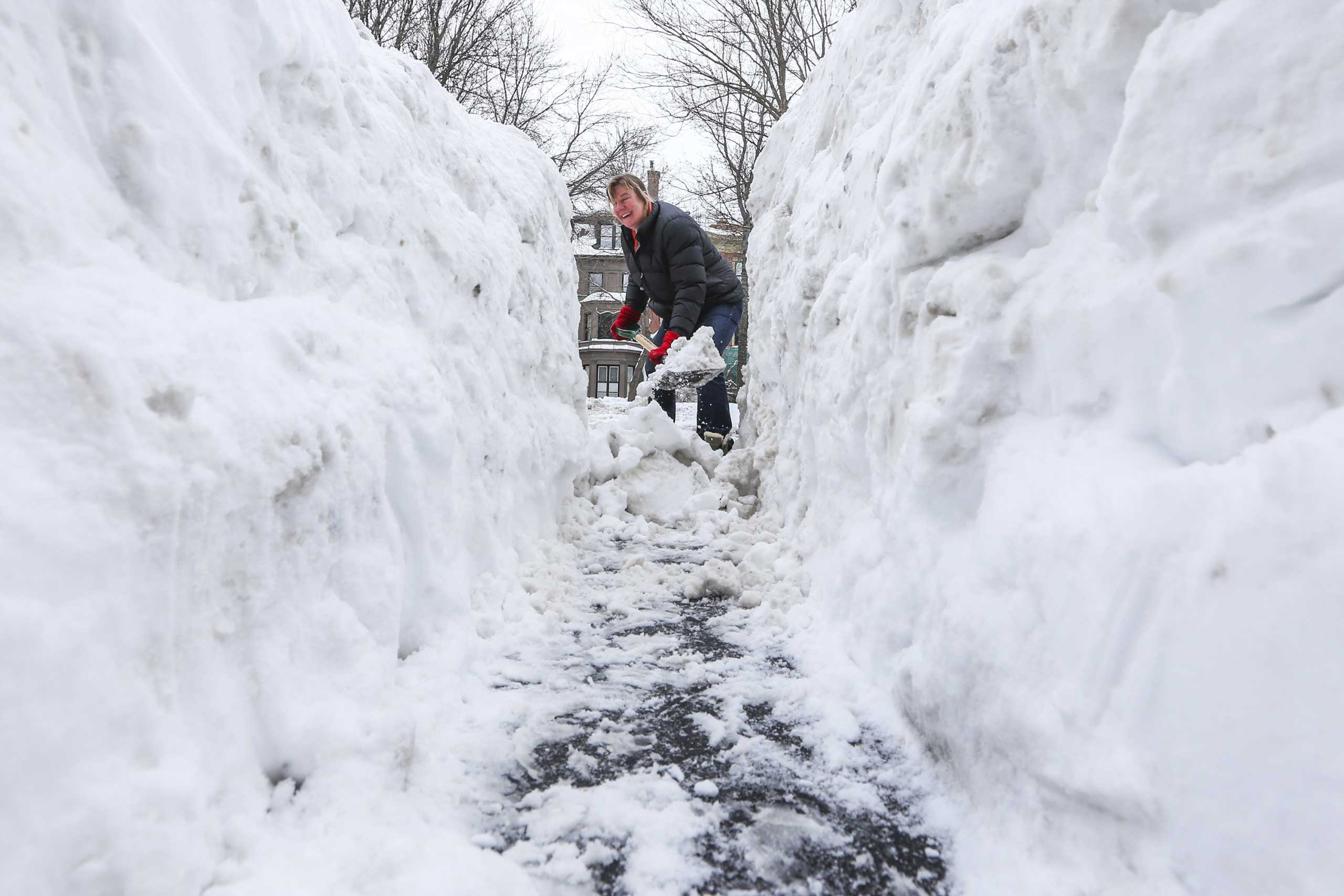 Ann Laborte shovels a path through the large mound of snow outside her Commonwealth Avenue home in Boston, Mass., Feb. 10, 2015.