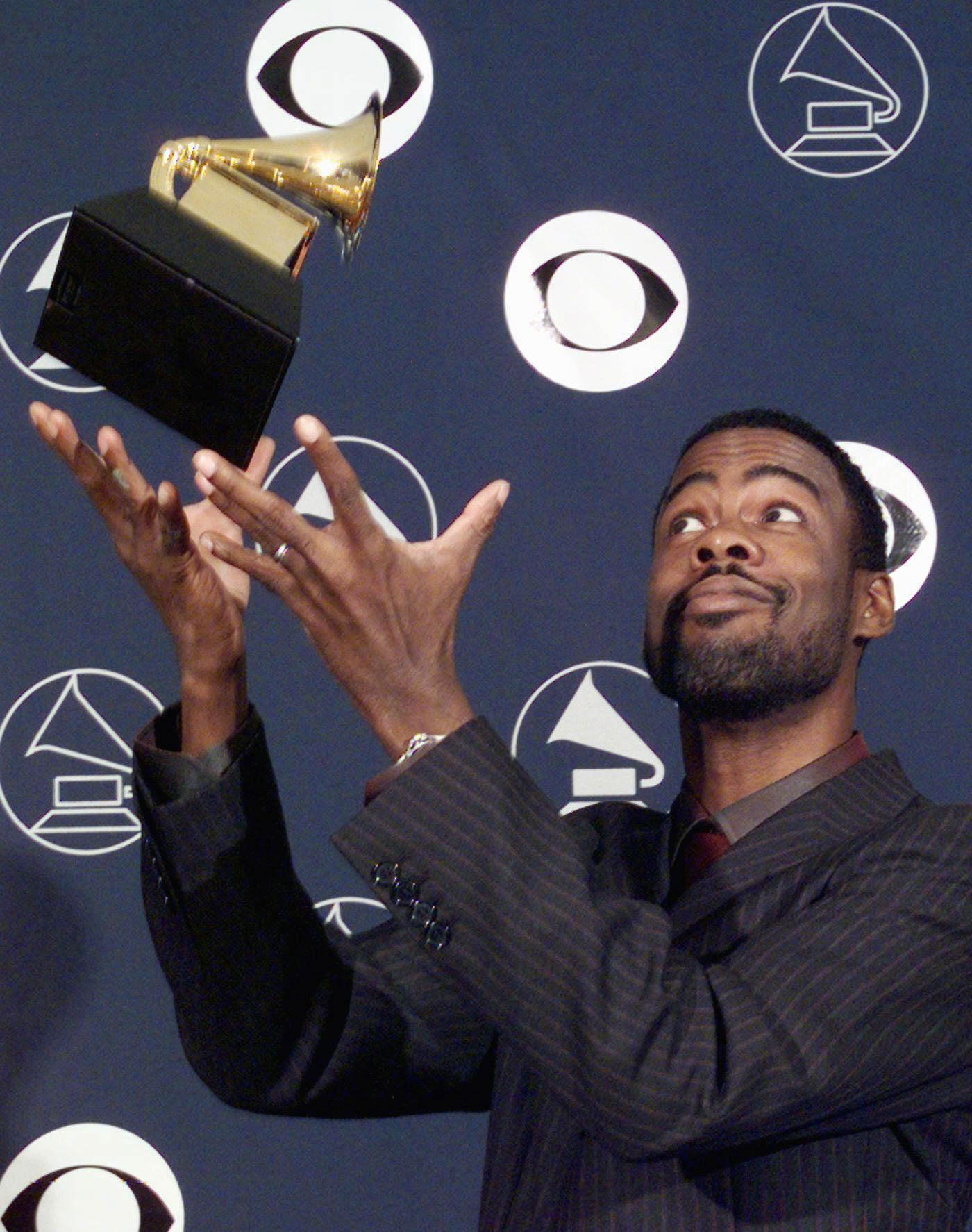Comedian Chris Rock throws his Grammy Award in the