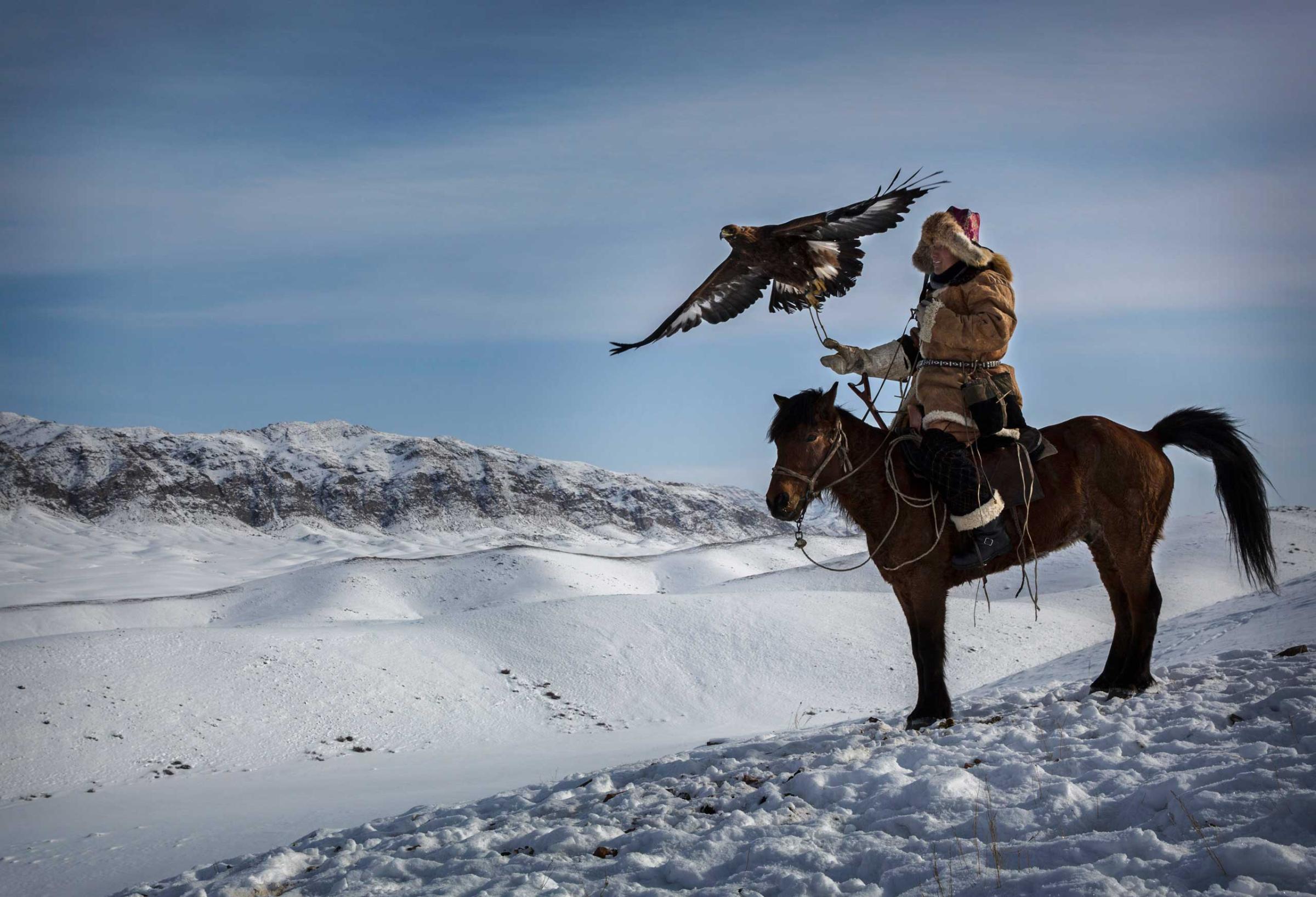 Chinese Kazakh eagle hunter releases his eagle during a local competition in the mountains of Qinghe County, Xinjiang, northwestern China.