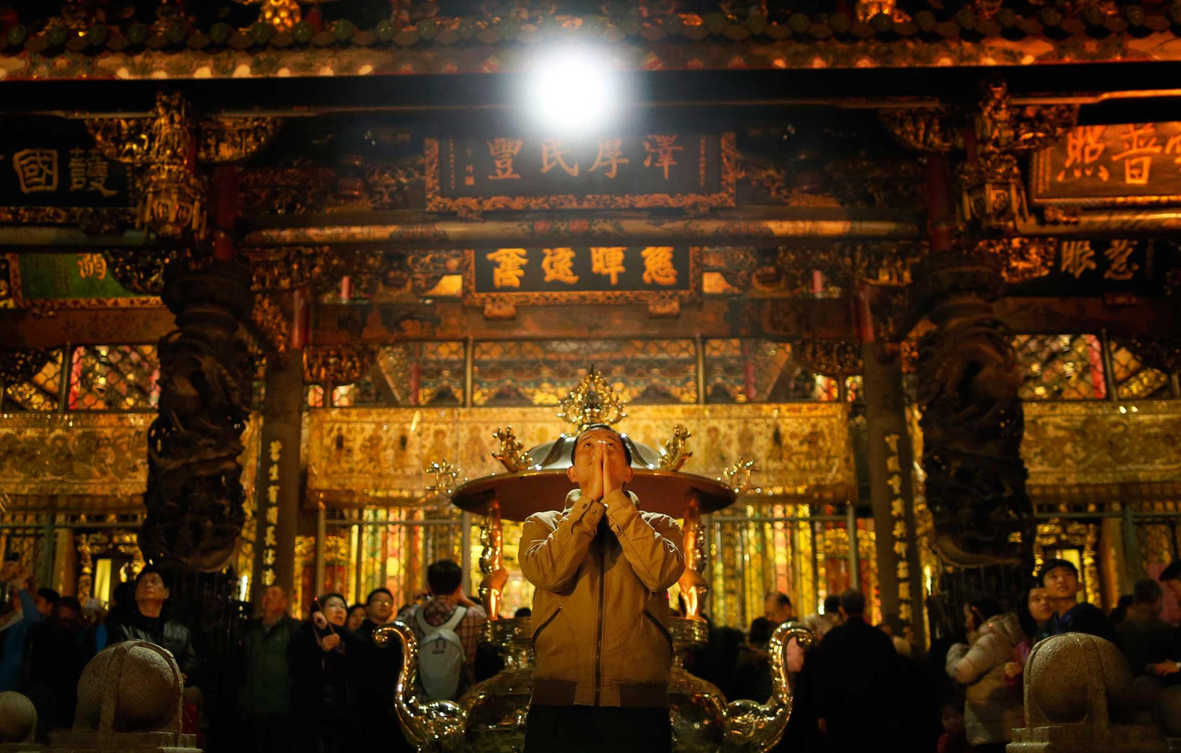 A devotee prays on the eve of the Chinese new year at the Lungshan Temple in Taipei, Taiwan, Feb. 18, 2015.