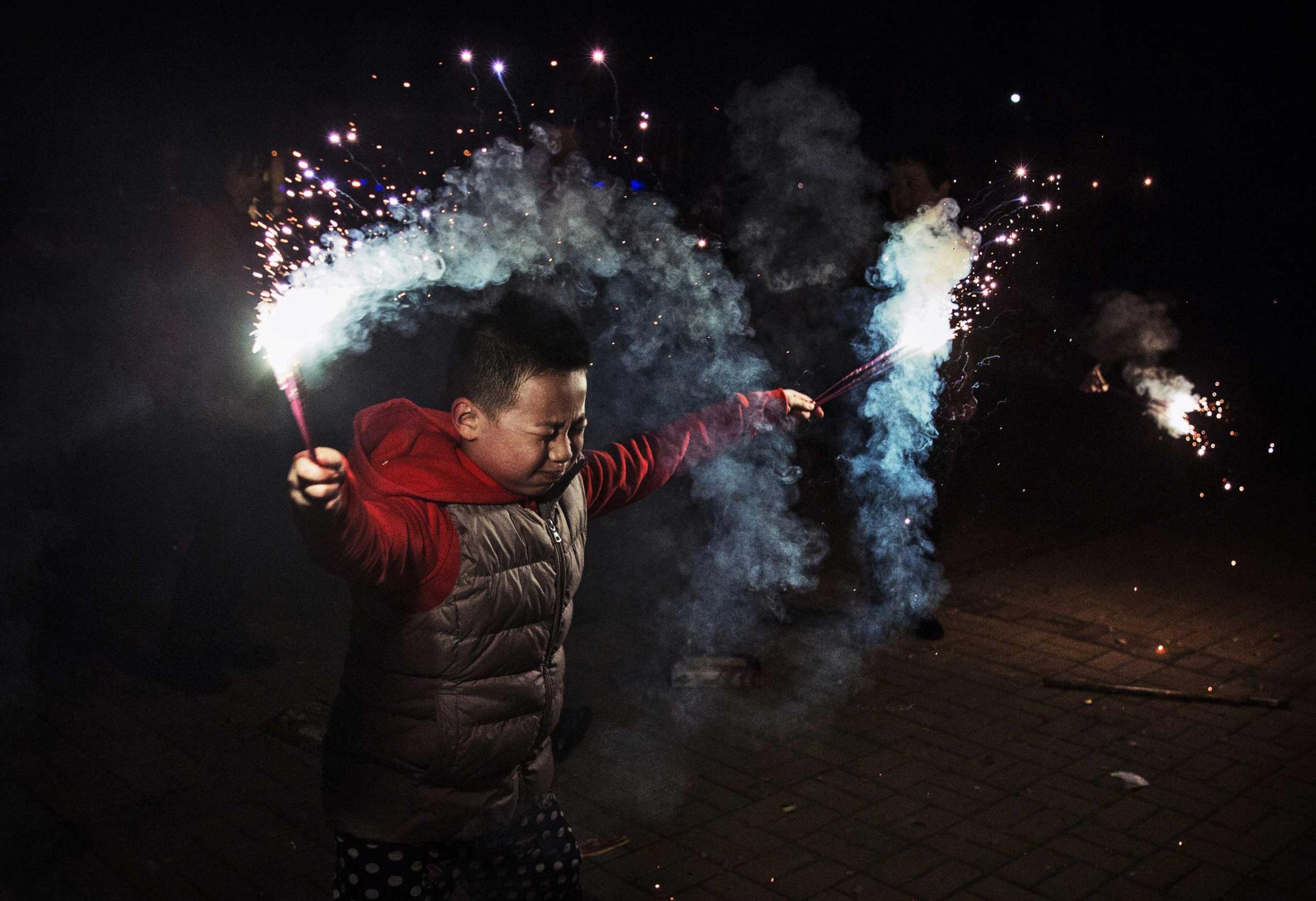 A Chinese boy uses sparklers during celebrations of the Lunar New early on Feb. 19, 2015 in Beijing.