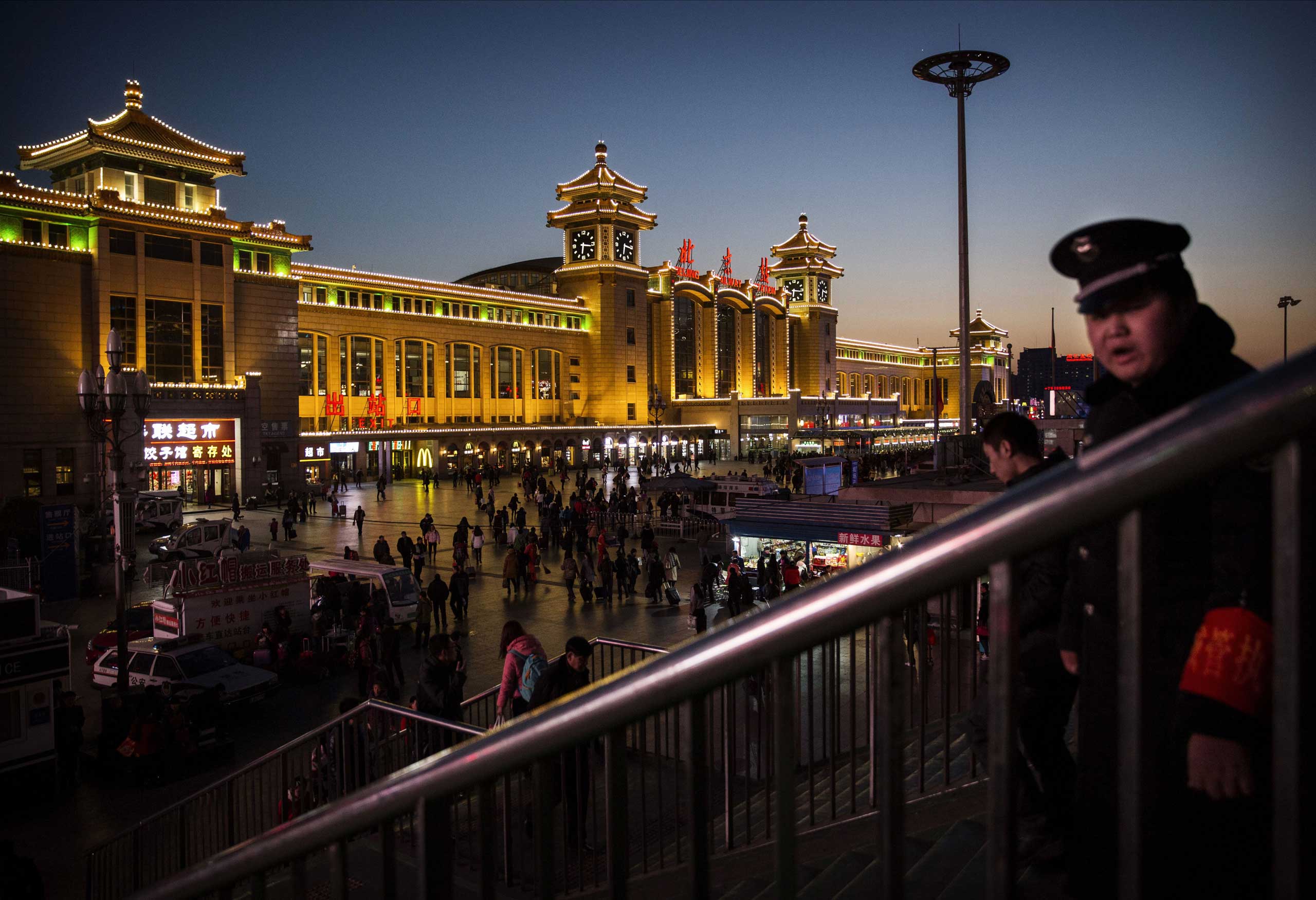 A security guard watches over passengers leaving for the Spring Festival at a local railway station on Feb. 17, 2015 in Beijing.
