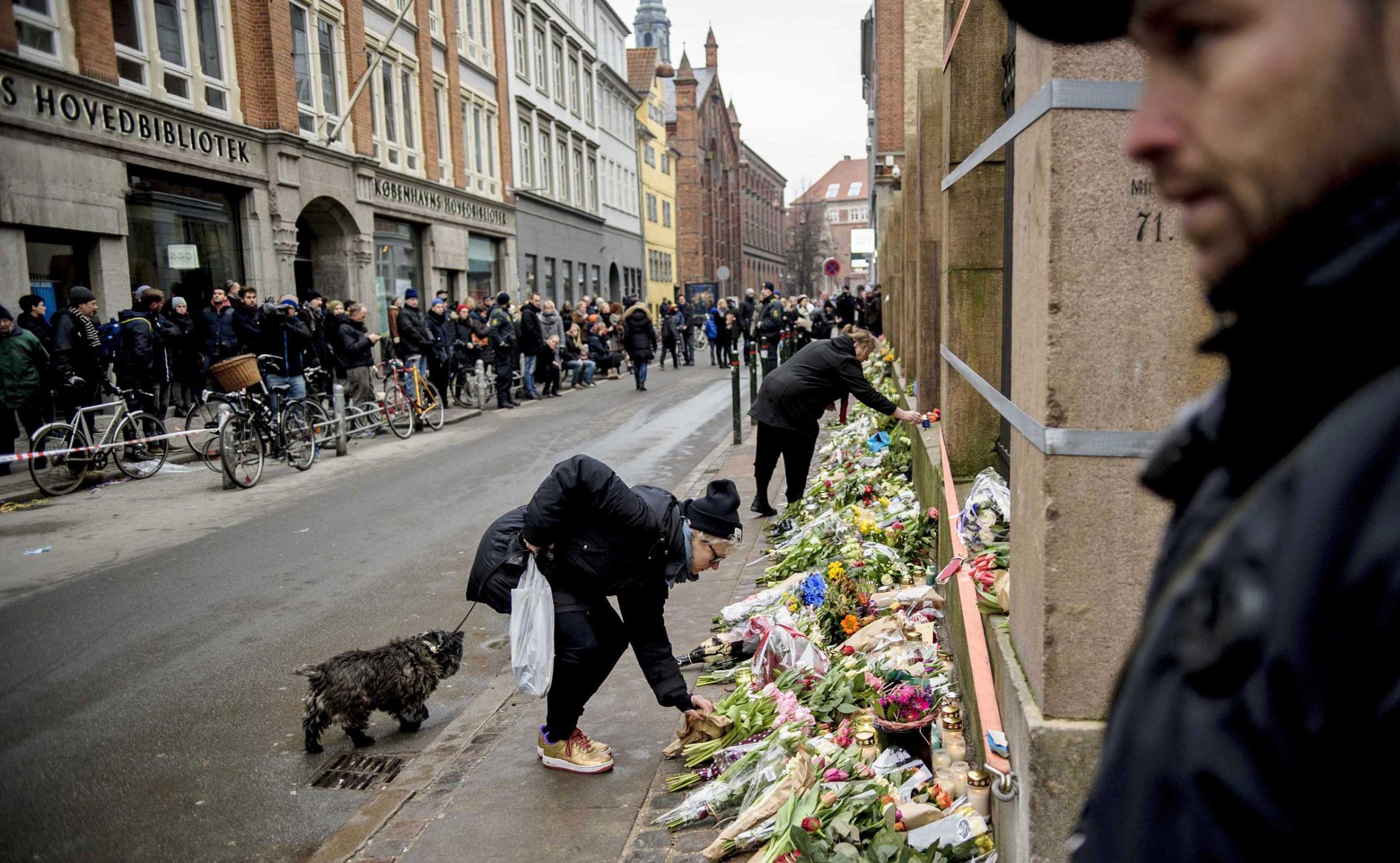 People lay flowers outside a synagogue where an attack took place in Copenhagen, Feb. 15, 2015.