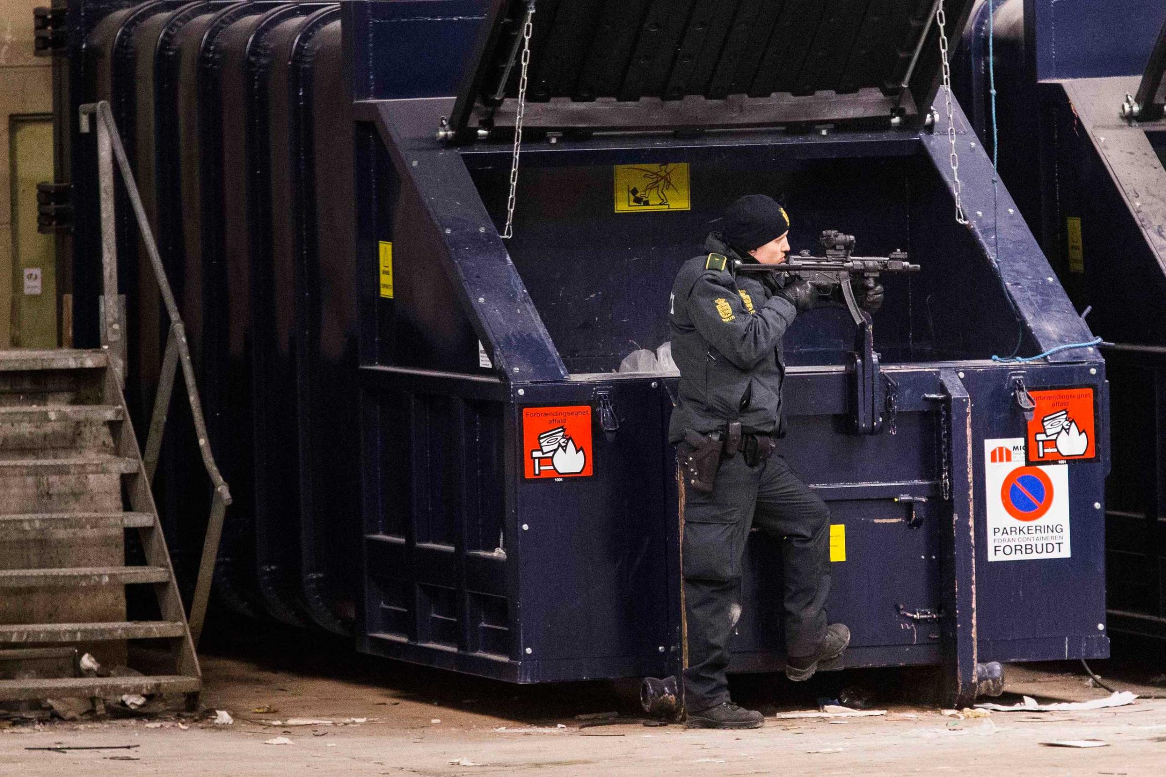 Armed police works in a cordoned off area in a street near Norrebro Station following shootings in Copenhagen, Feb. 15, 2015.