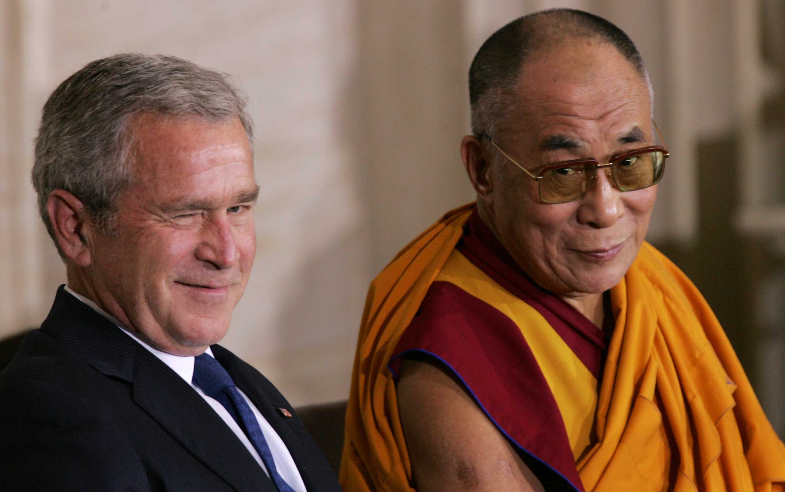 President George W. Bush winks while he sits with the Dalai Lama during a ceremony to present him with the Congressional Gold Medal in Washington, D.C., in October 2007.