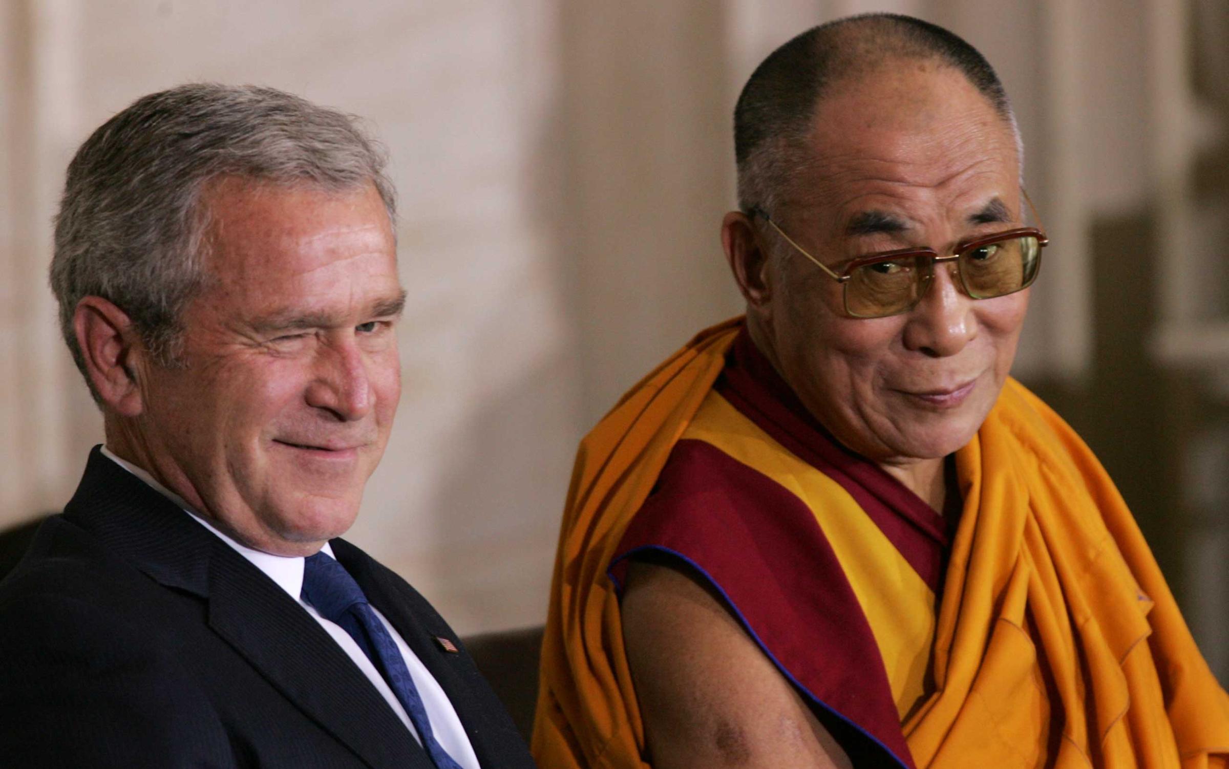 President George W. Bush winks while he sits with His Holiness the 14th Dalai Lama of Tibet during a ceremony presenting the Congressional Gold Medal to the Dalai Lama in the Rotunda of the US Capitol in Washington, DC, Oct. 2007.