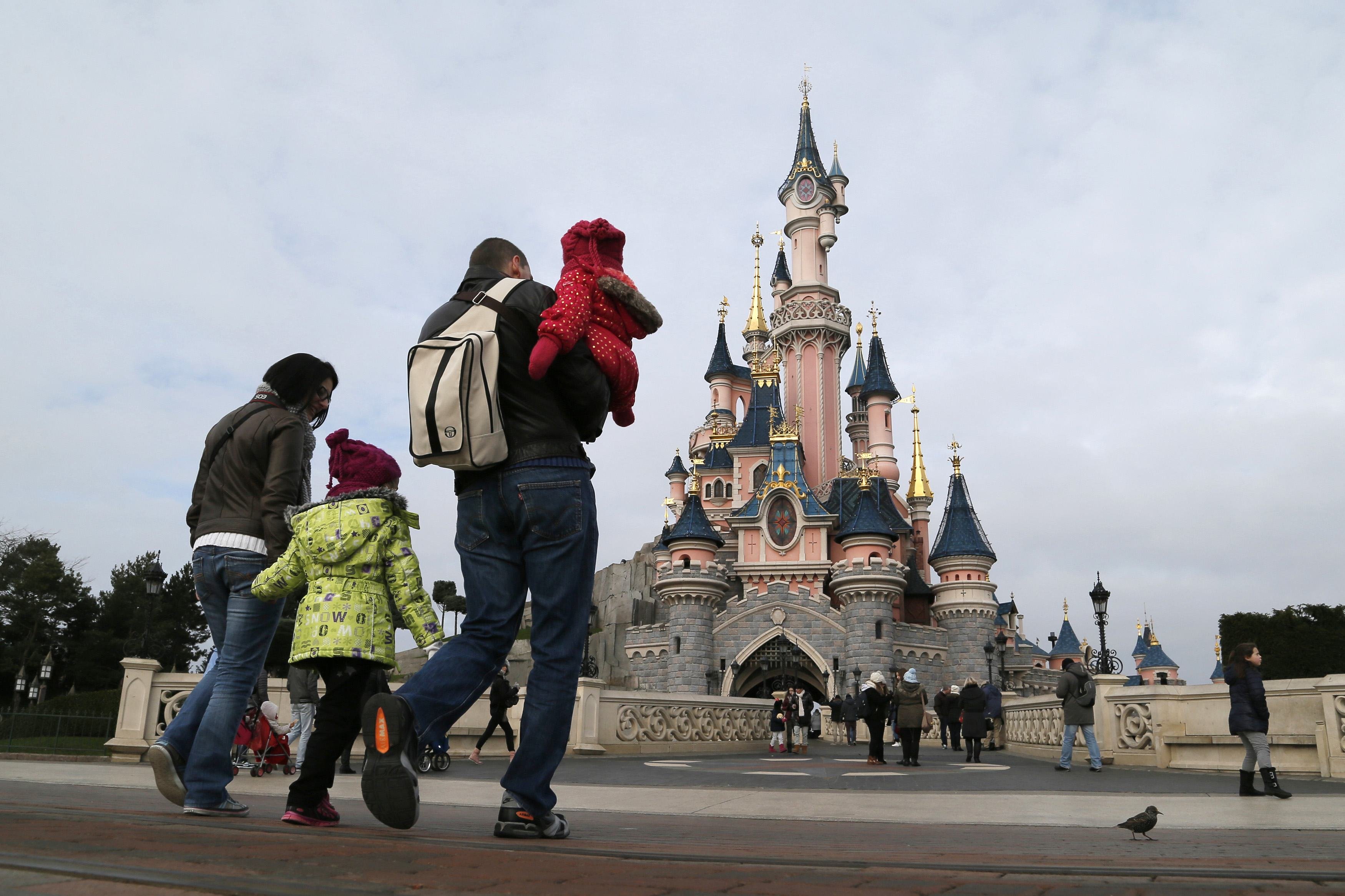 Visitors walk towards the Sleeping Beauty Castle during a visit to the Disneyland Paris Resort run by EuroDisney S.C.A in Marne-la-Vallee on Jan. 21, 2015. (Gonzalo Fuentes—Reuters)