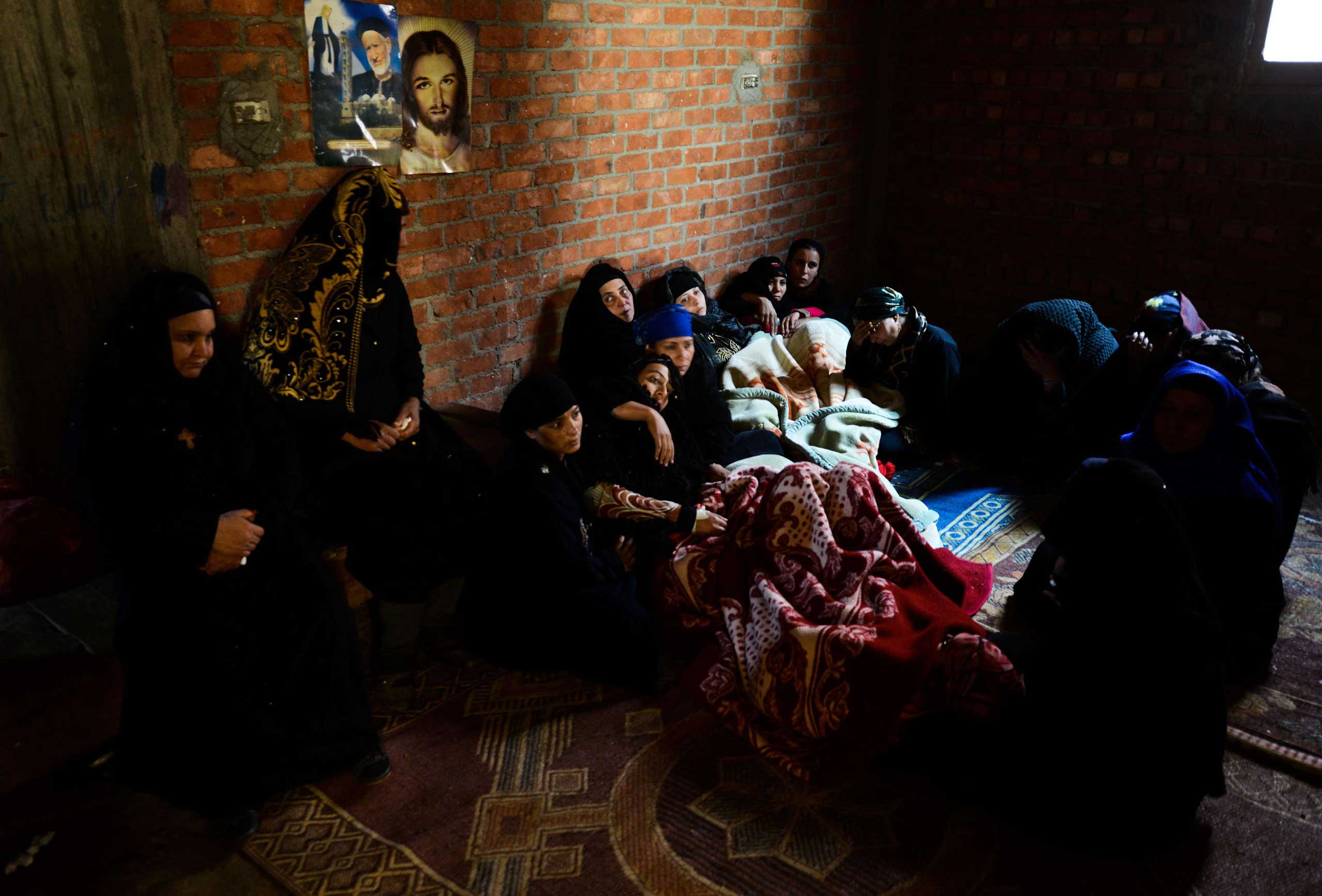 Relatives of Egyptian Coptic Christians purportedly murdered by ISIS militants in Libya sit inside a house after hearing the news on Feb. 16, 2015 in the village of Al-Our in Egypt's southern province of Minya.
