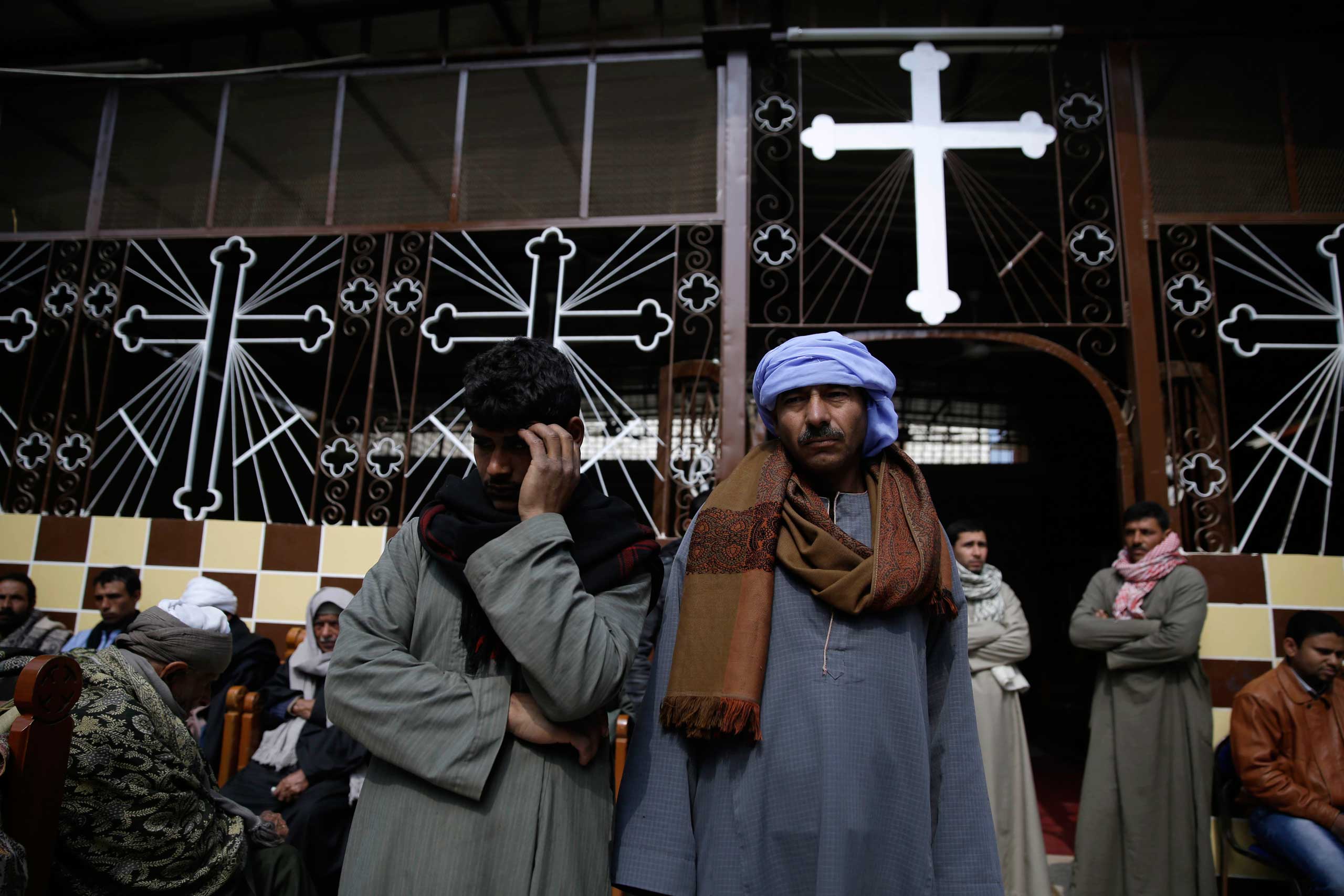 Men mourn over the Egyptian Coptic Christians who were captured in Libya and killed by militants affiliated with ISIS, at the Virgin Mary church in the village of Al-Our, near Minya, 135 miles south of Cairo, Feb. 16, 2015.