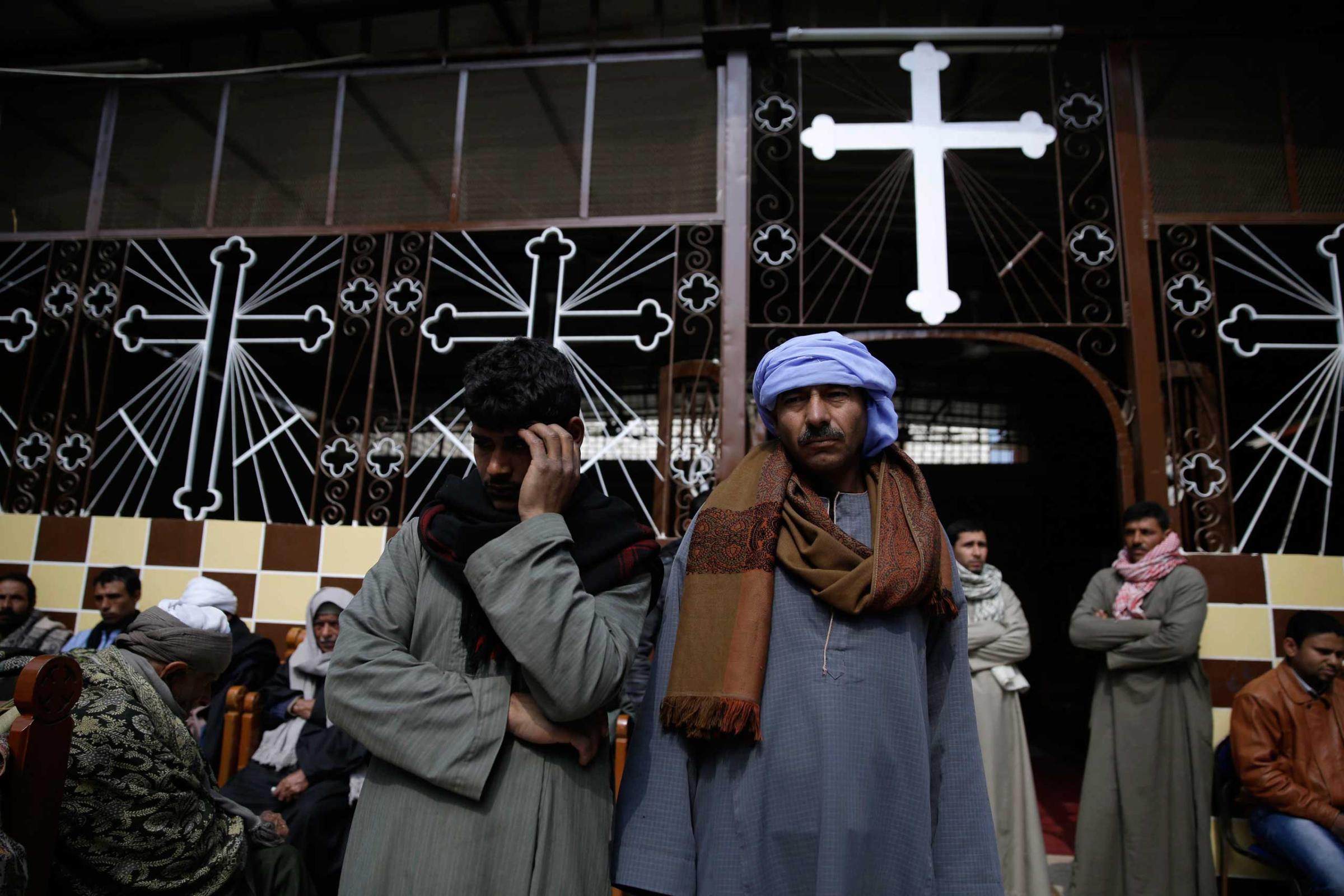 Men mourn over the Egyptian Coptic Christians who were captured in Libya and killed by militants affiliated with the Islamic State group, at the Virgin Mary church in the village of el-Aour, near Minya, 135 miles south of Cairo, Feb. 16, 2015.