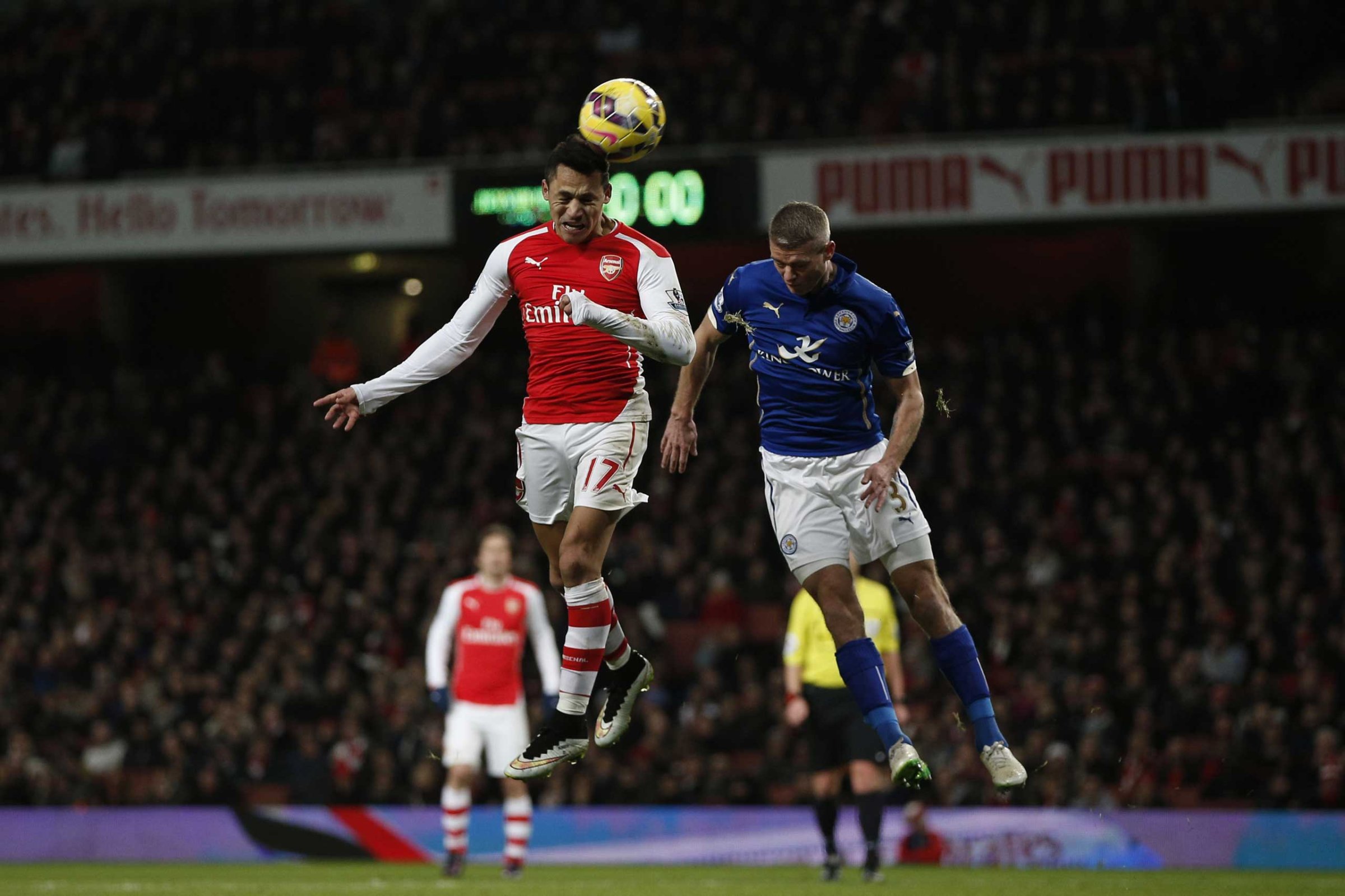 Arsenal's Chilean striker Alexis Sanchez heads the ball ahead of Leicester City's English defender Paul Konchesky during the English Premier League football match between Arsenal and and Leicester City at the Emirates Stadium in London on Feb. 10, 2015.