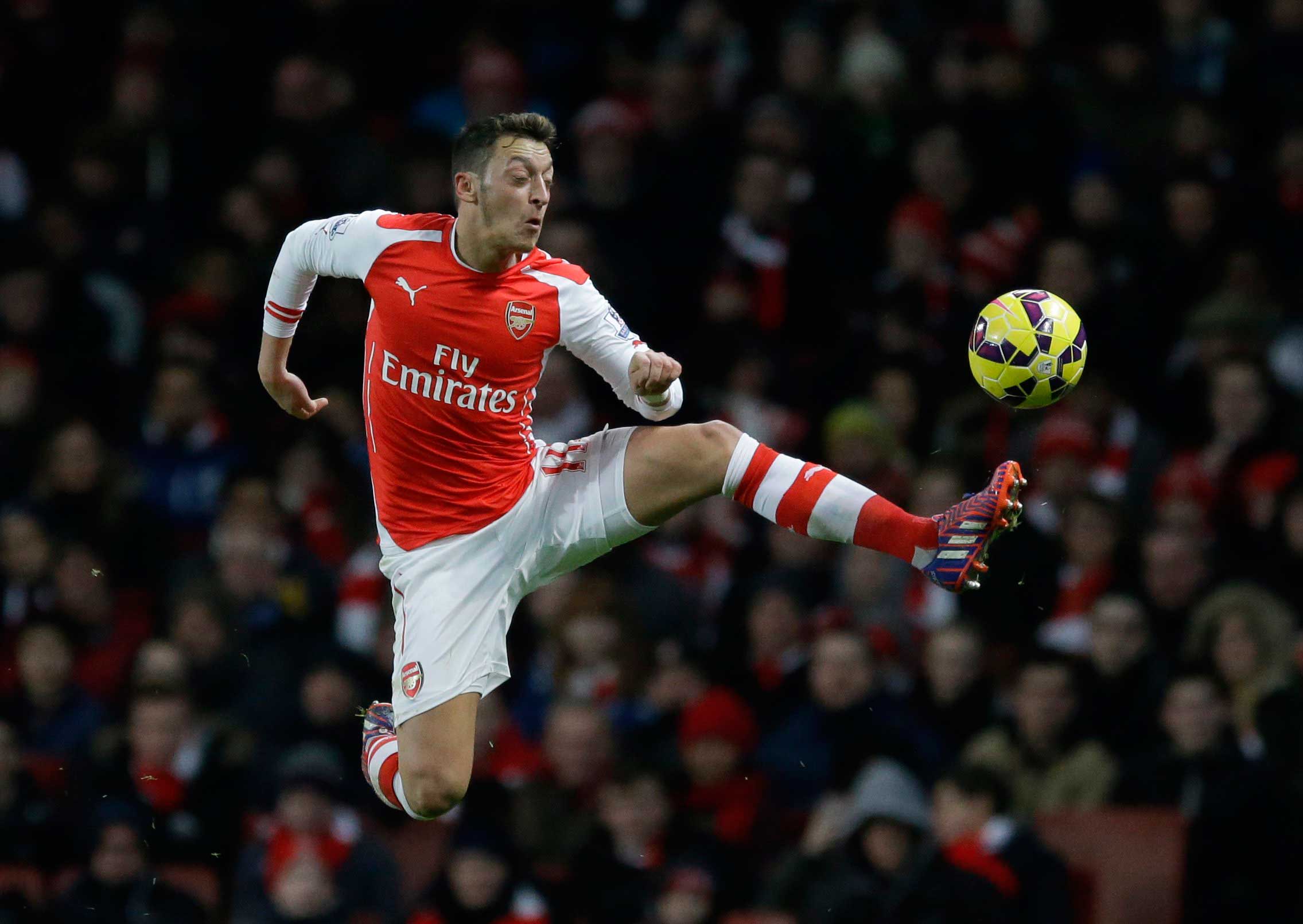Arsenal's Mesut Ozil controls the ball during the English Premier League soccer match between Arsenal and Leicester City at the Emirates Stadium in London, Feb. 10, 2015.