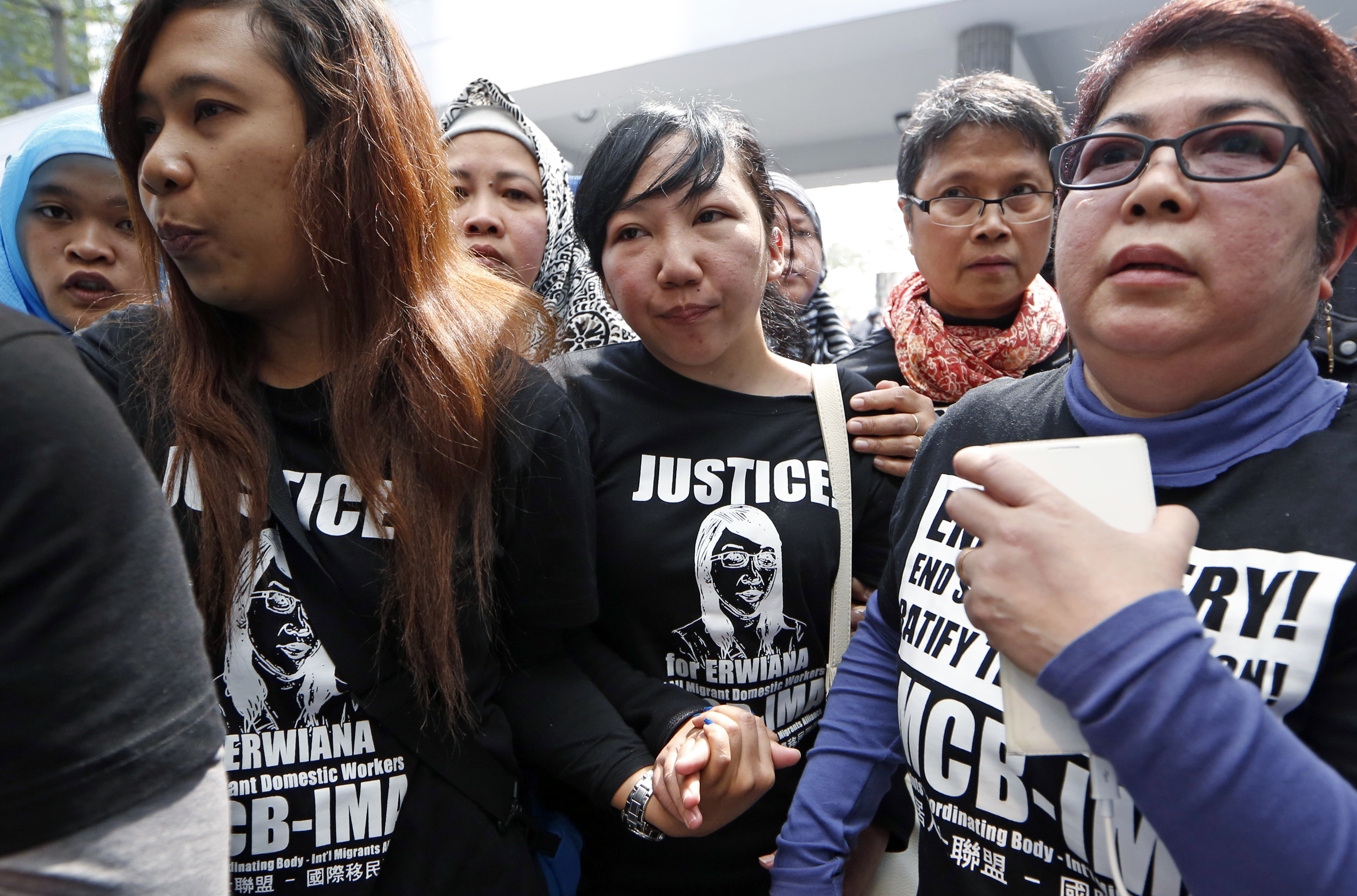 Indonesian maid Erwiana Sulistyaningsih, center, accompanied by her supporters, walks out from a court in Hong Kong on Feb. 10, 2015 (Kin Cheung—AP)