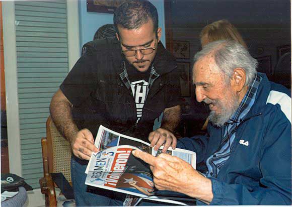 Former Cuban President Fidel Castro and President of Cuba's University Students Federation (FEU) Randy Perdomo look at a newspaper during a meeting in Havana on Jan. 23, 2015. (Cubadebate/Reuters)