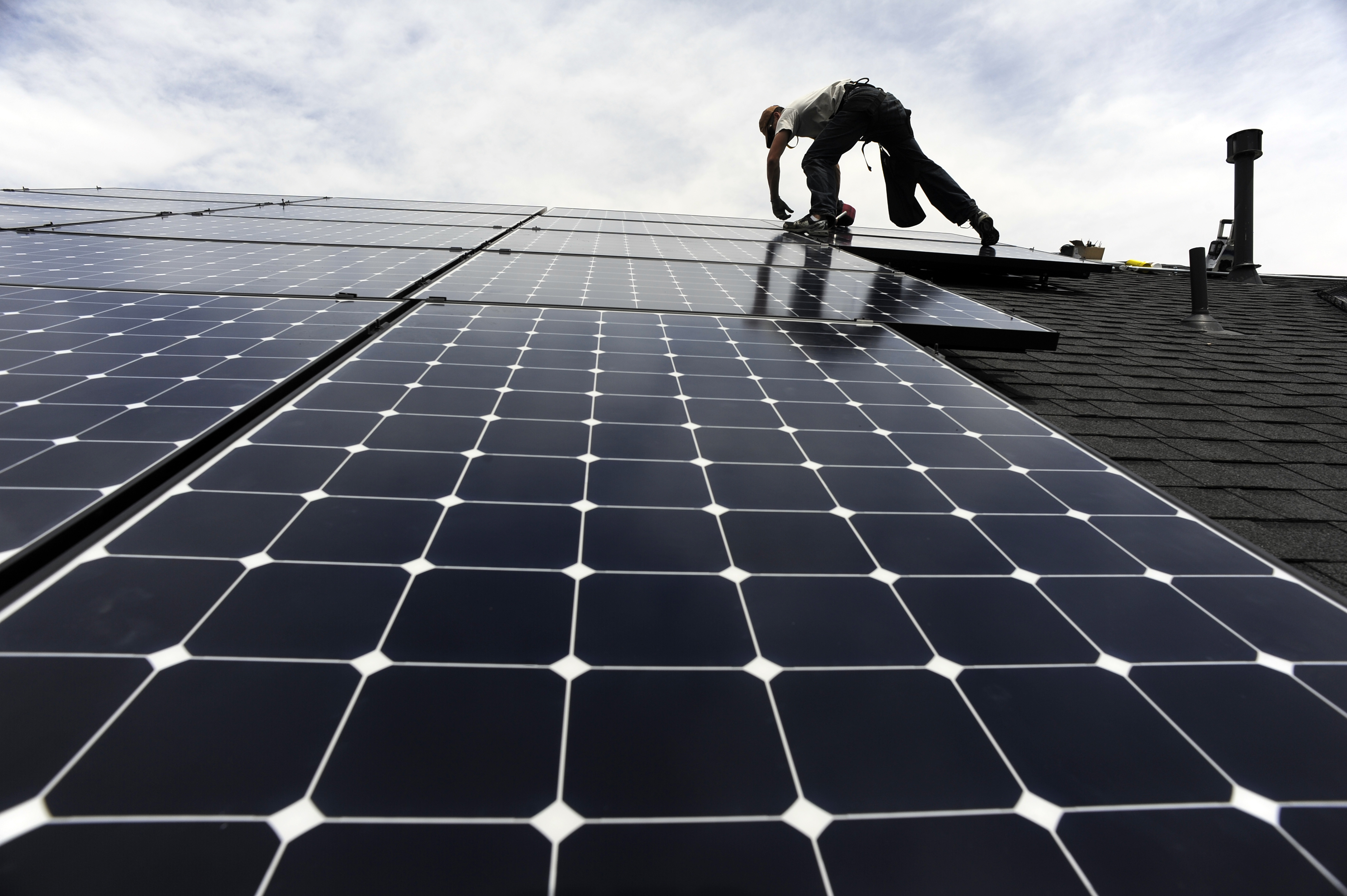 Solar installer, Justin Woodbury, Namaste (accent over the e) Solar, secures solar panels for a photovoltaic solar array system on the roof of a house in the Sorrel Ranch area, near e-470 and Smoky hill Road in Aurora Friday afternoon in record temperatur