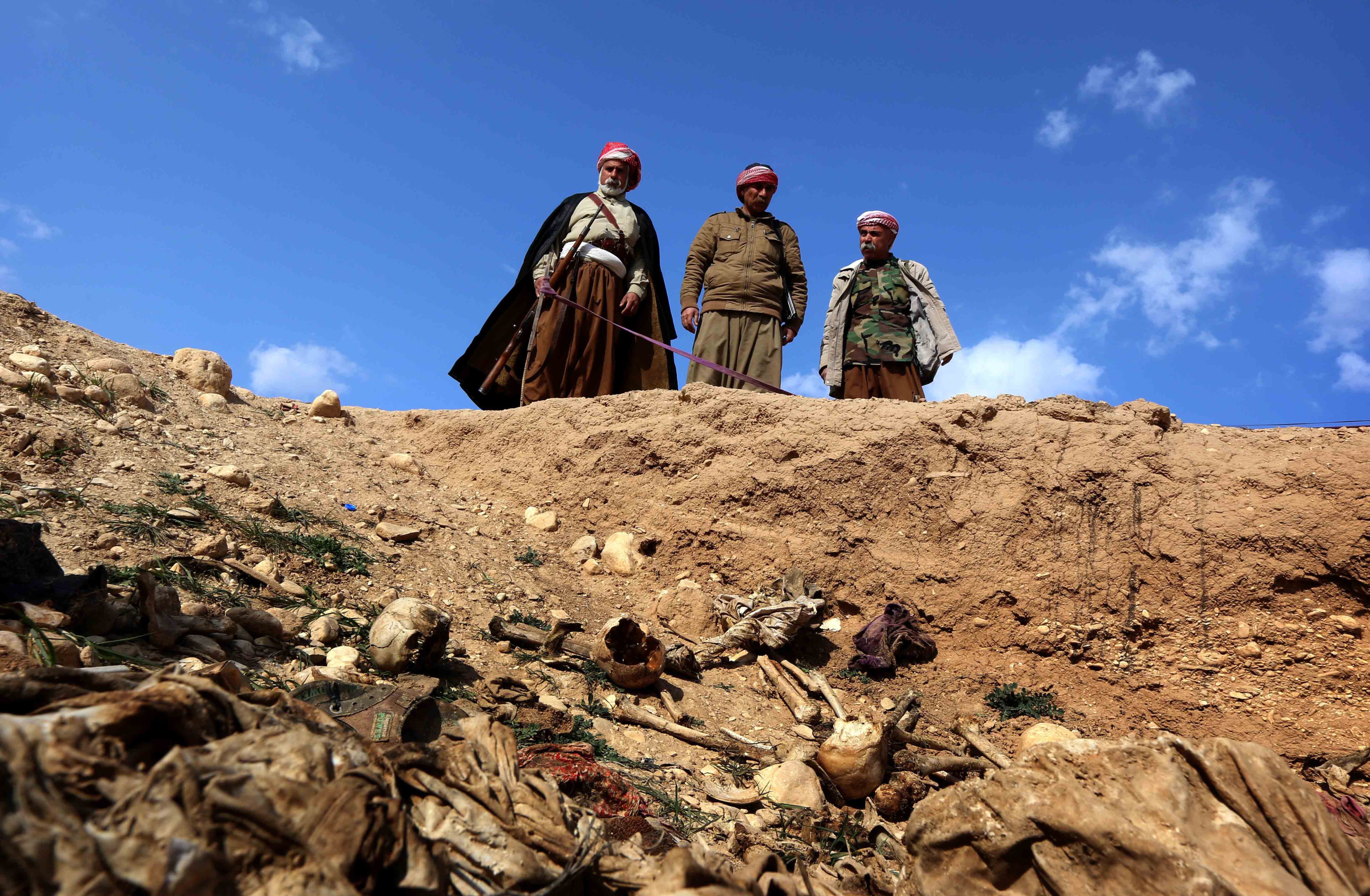Members of the Yazidi minority search for clues on February 3, 2015, that might lead them to missing relatives in the remains of people killed by the Islamic State (IS) jihadist group, a day after Kurdish forces discovered a mass grave near the Iraqi village of Sinuni, in the northwestern Sinjar area. (SAFIN HAMED—AFP/Getty Images)