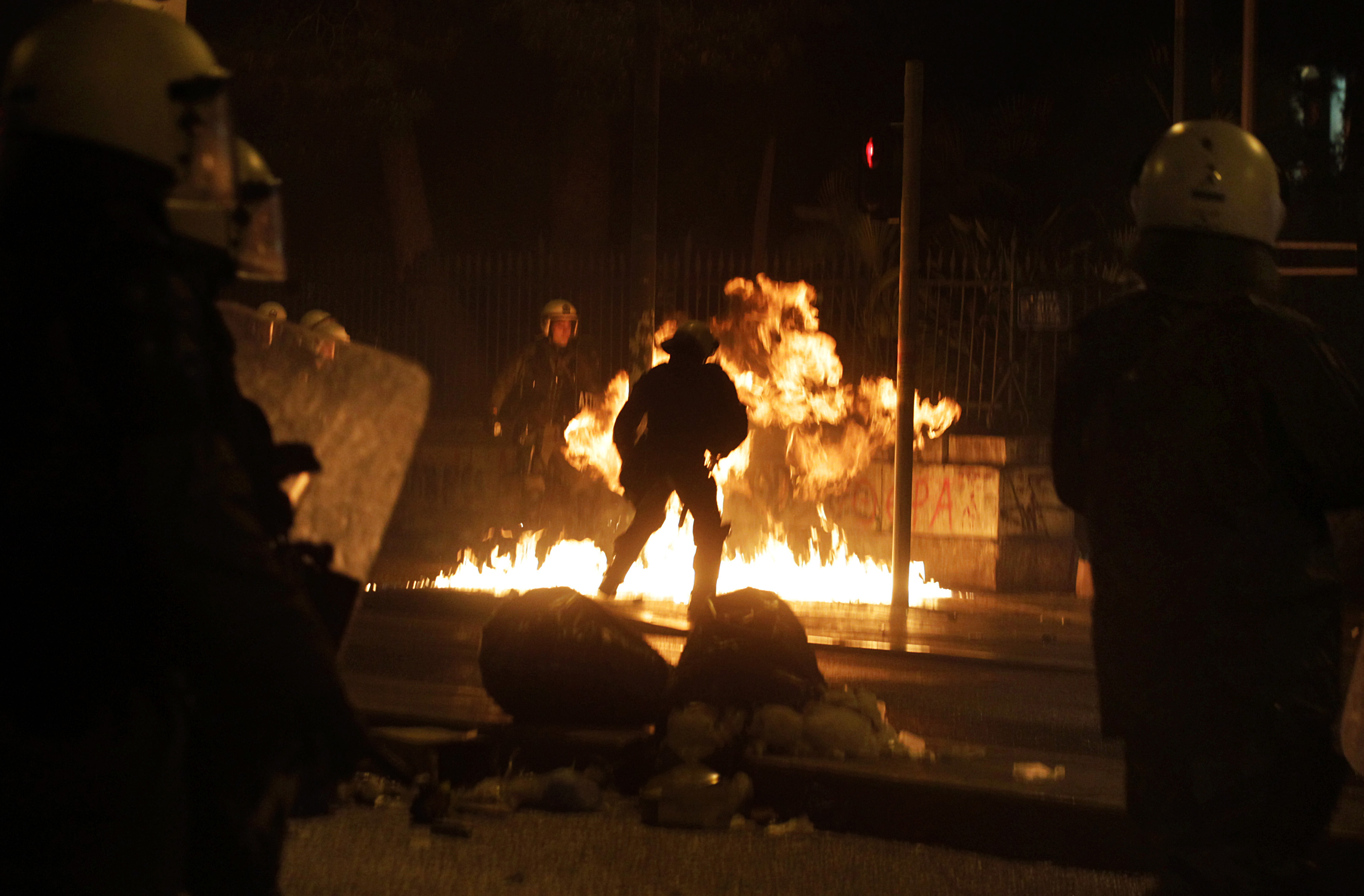 Riot policemen try to avoid a molotov cocktail during clashes after the end of an antigovernment protest called by leftist groups in Athens on Feb. 26, 2015 (ORESTIS PANAGIOTOU—EPA)