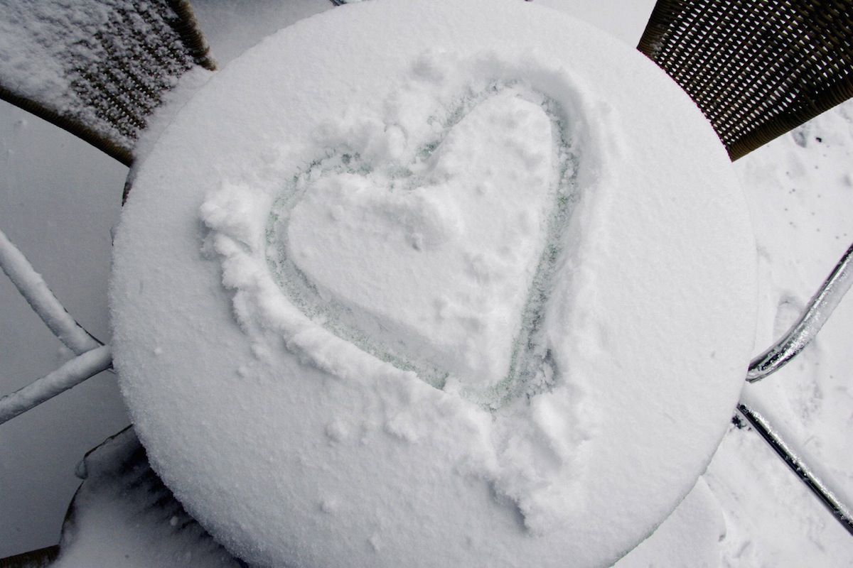 A heart is painted in the snow on a tabl