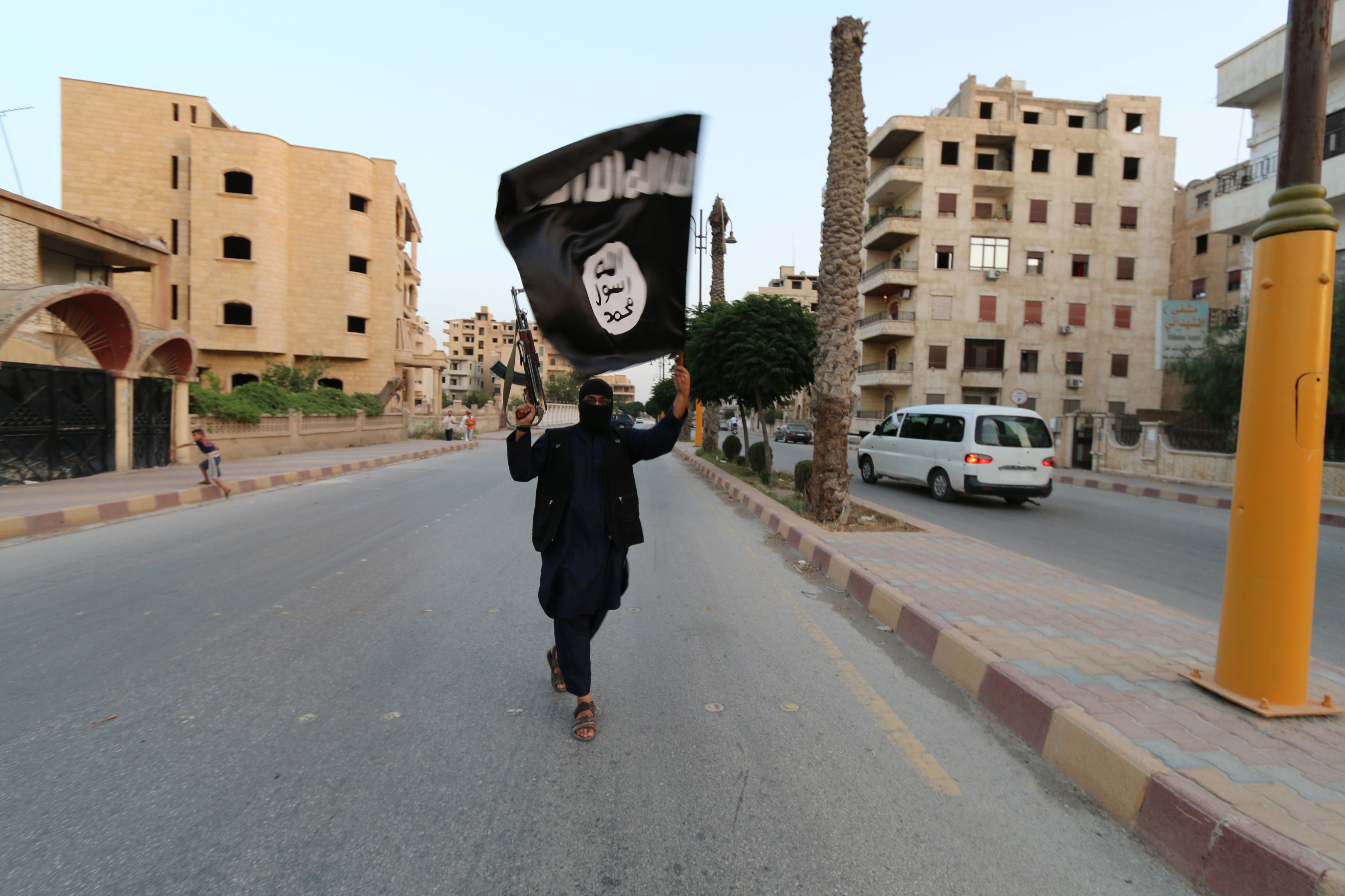 A member loyal to the Islamic State in Iraq and the Levant waves an ISIS flag in Raqqa on June 29, 2014. (Reuters)