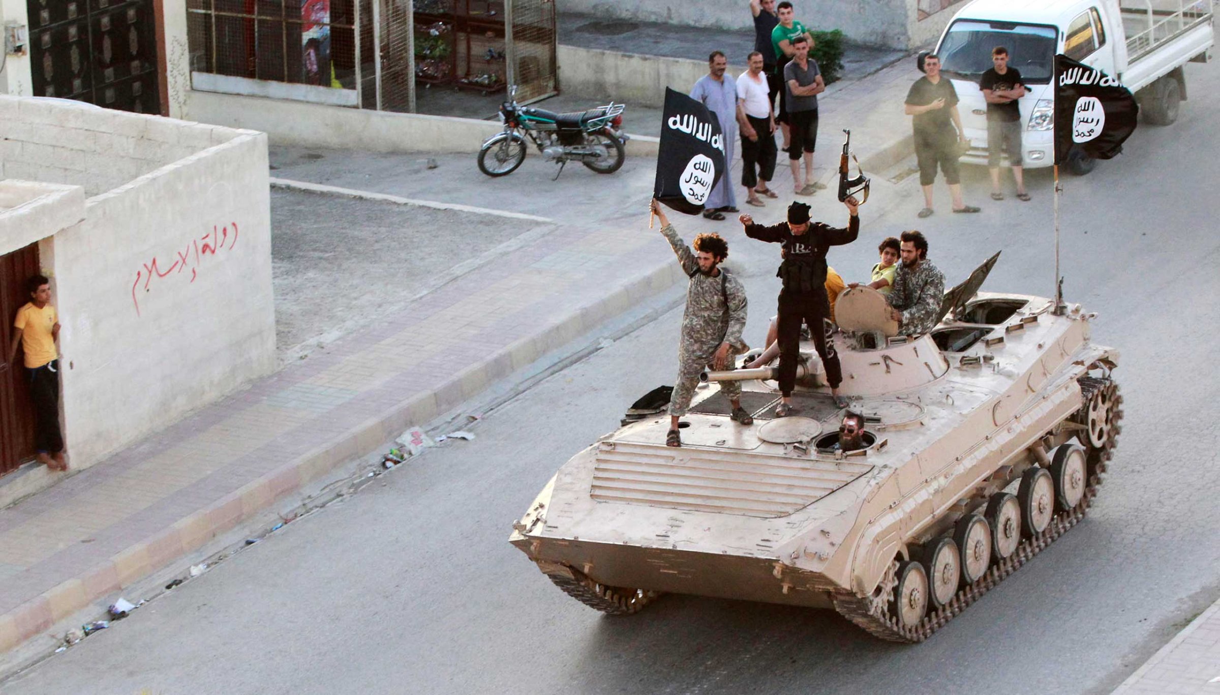 Militant Islamist fighters take part in a military parade along the streets of northern Raqqa province, June 2014.