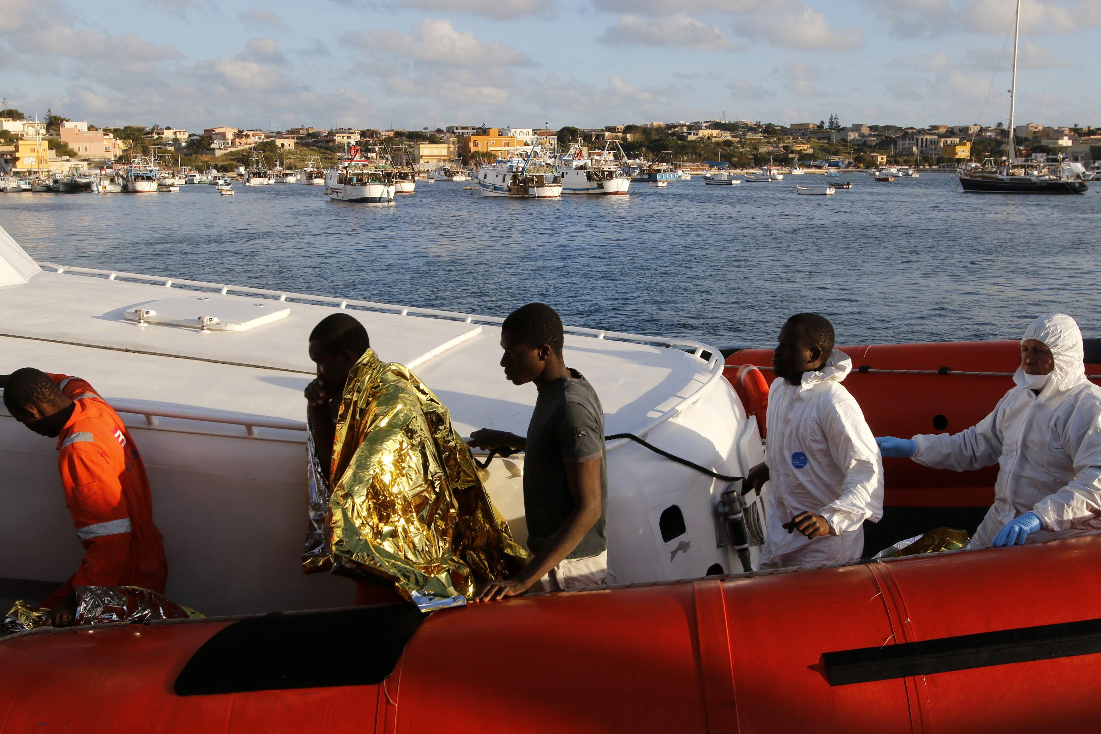 Migrants who survived a shipwreck arrive at the Lampedusa harbour