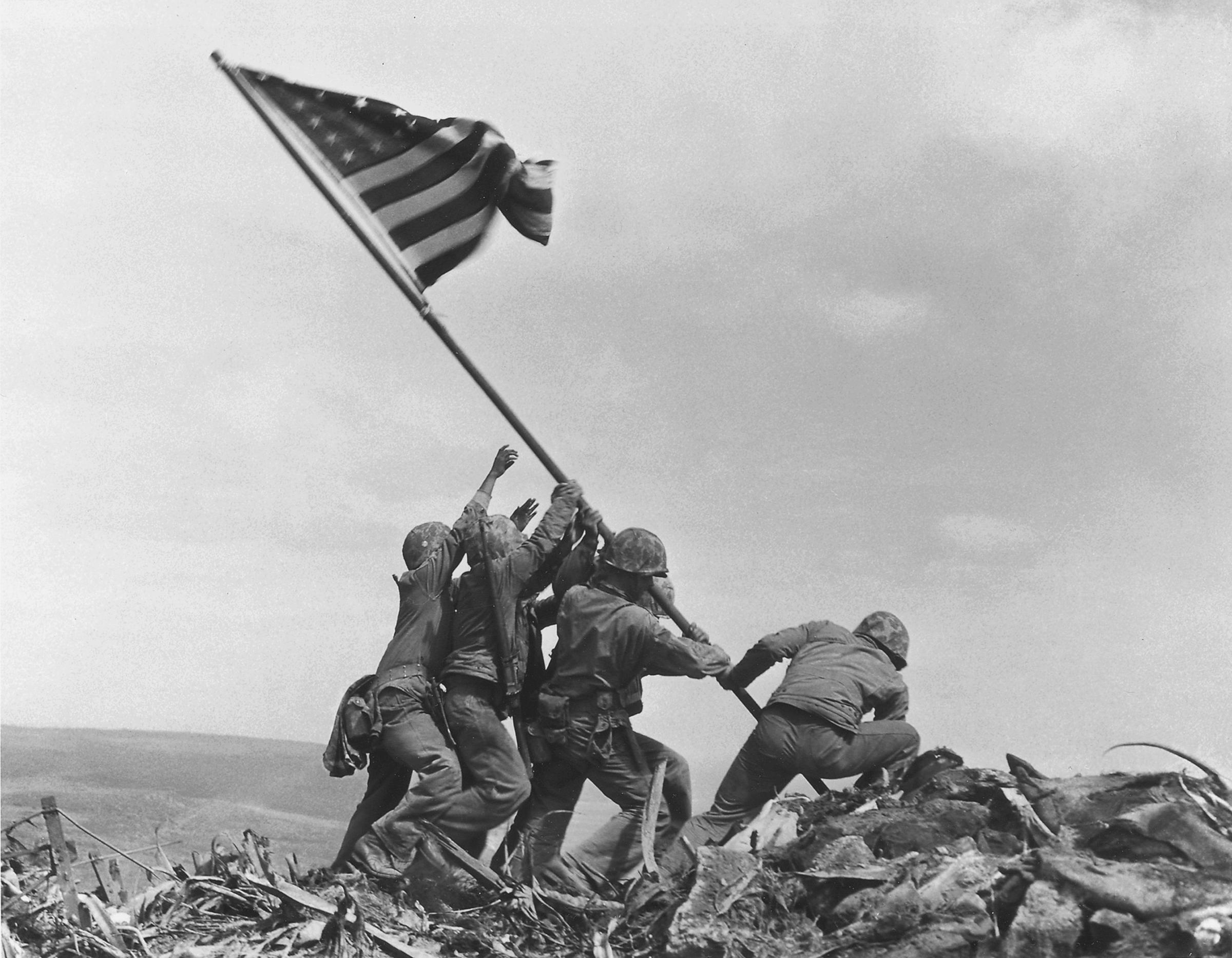 U.S. Marines of the 28th Regiment, 5th Division, raise the American flag atop Mt. Suribachi, Iwo Jima, on Feb. 23, 1945. Strategically located only 660 miles from Tokyo, the Pacific island became the site of one of the bloodiest, most famous battles of World War II against Japan.