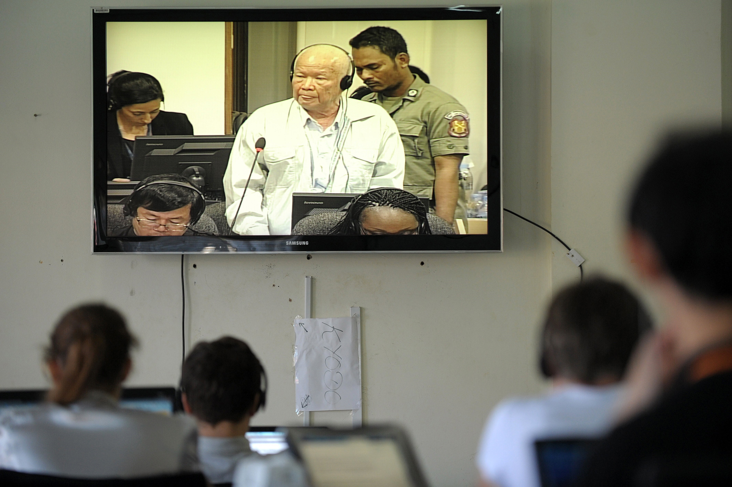 Cambodian and international journalists watch a live video feed showing former Khmer Rouge head of state Khieu Samphan during a hearing for his trial at the Extraordinary Chamber in the Courts of Cambodia in Phnom Penh on Jan. 8, 2015 (Tang Chhin Sothy—AFP/Getty Images)