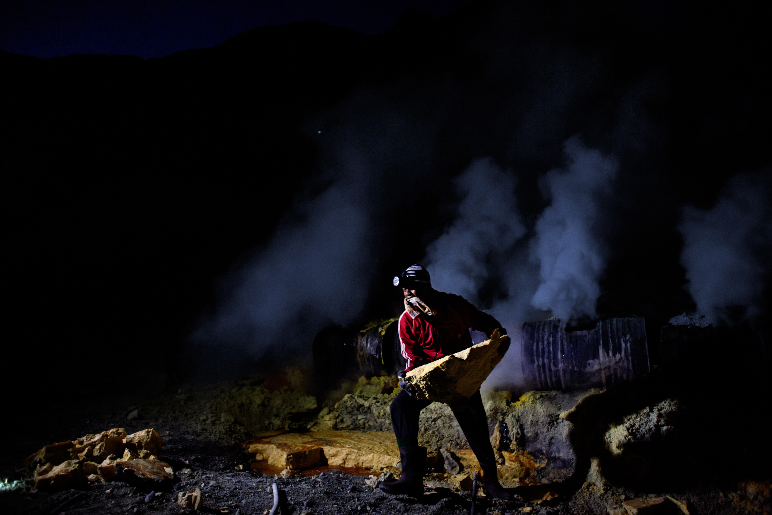 Sariman, 23, lifts a huge sulfur slab at Kawah Ijen volcano, Nov. 2, 2014.
