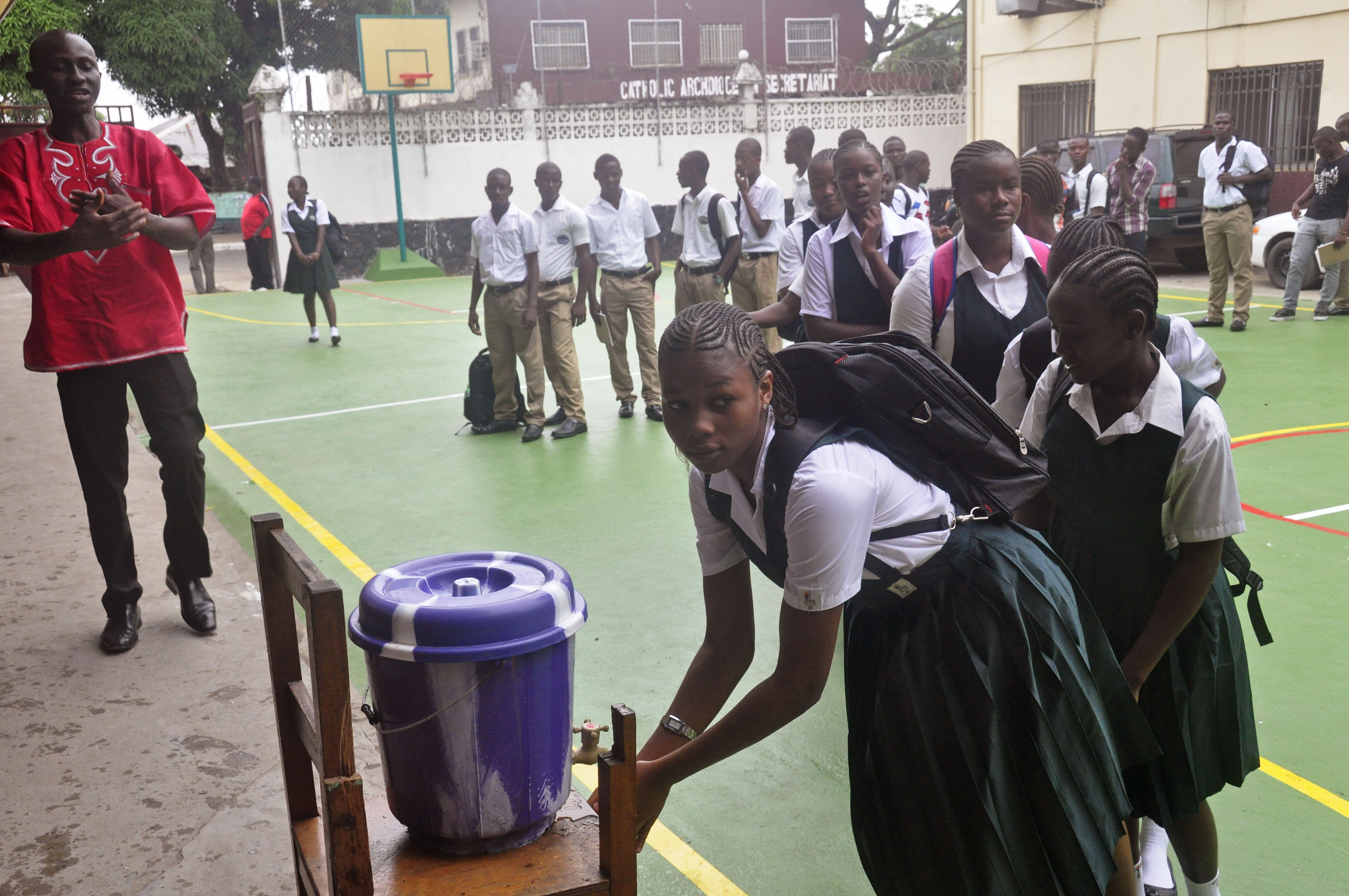 Liberian school children wash their hands before entering their classrooms as part of the Ebola prevention measures at Cathedral High School as students arrive in the morning to attend class in Monrovia, Liberia, Feb. 16, 2015. (Abbas Dulleh—AP)