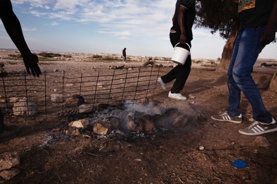 A group of detainees finishing up a barbeque in the desert. Many don’t feel like they are being feed well in Holot, so detainees form groups and put their money together in a pot that they use to buy their own food.