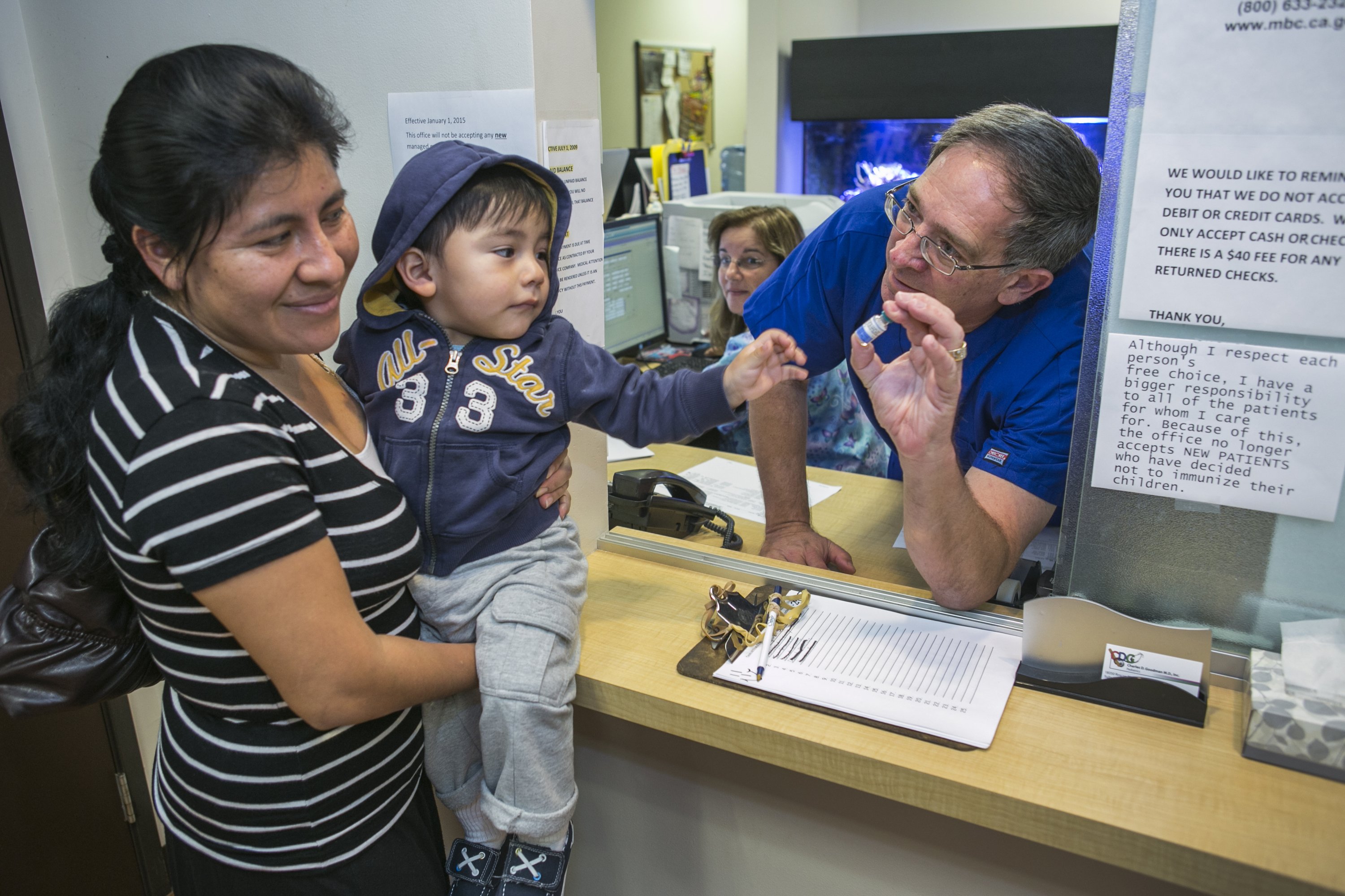 Pediatrician Dr. Charles Goodman talks with Carmen Lopez, who is holding her 18-month-old son Daniel after being vaccinated with the measles-mumps-rubella (MMR) vaccine, at his practice in Northridge, Calif., on Jan. 29, 2015 (Damian Dovarganes—AP)