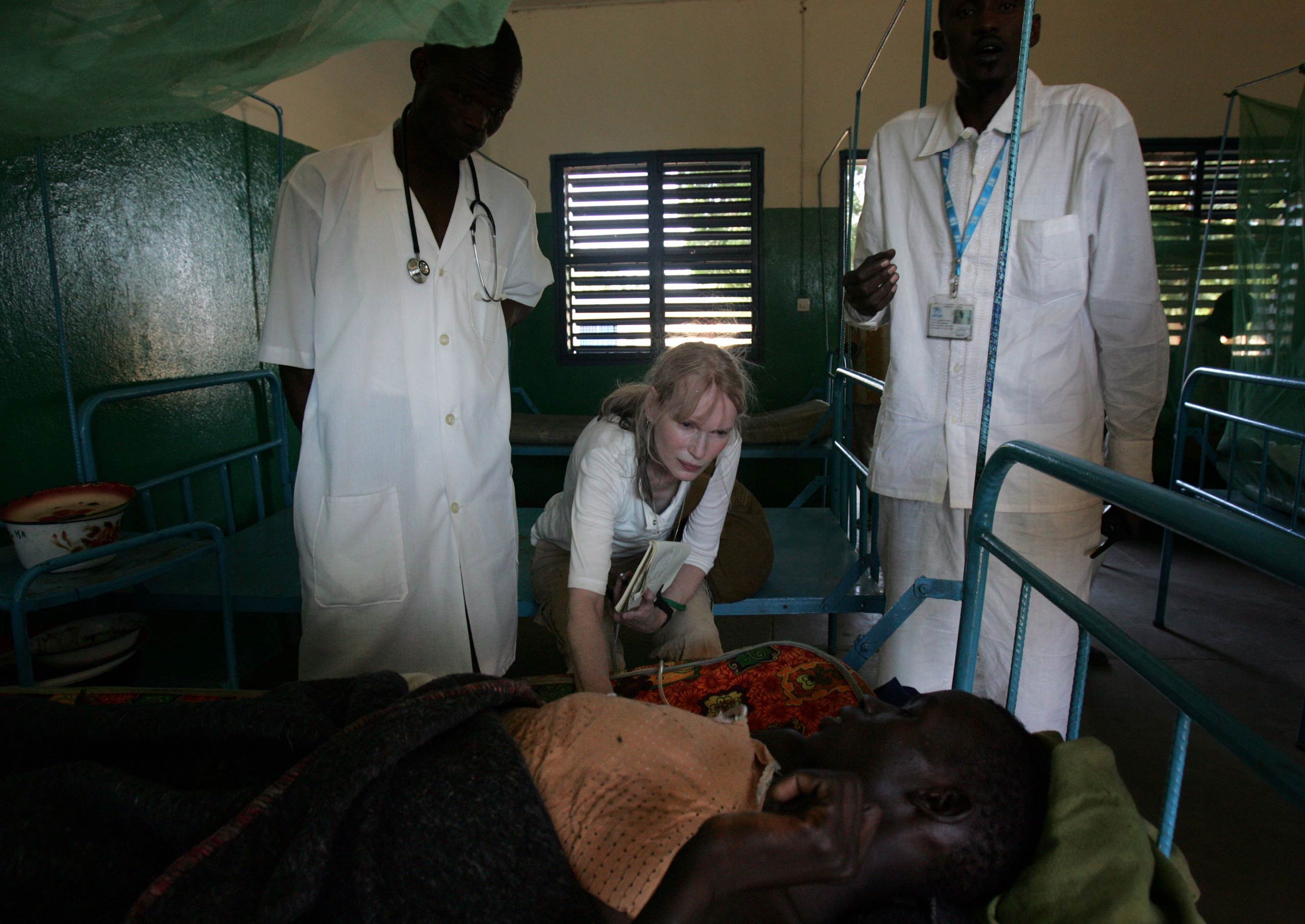 Mia Farrow talks to a wounded Chadian internally displaced person on Nov. 15, 2006, in Goz Beida, Chad.