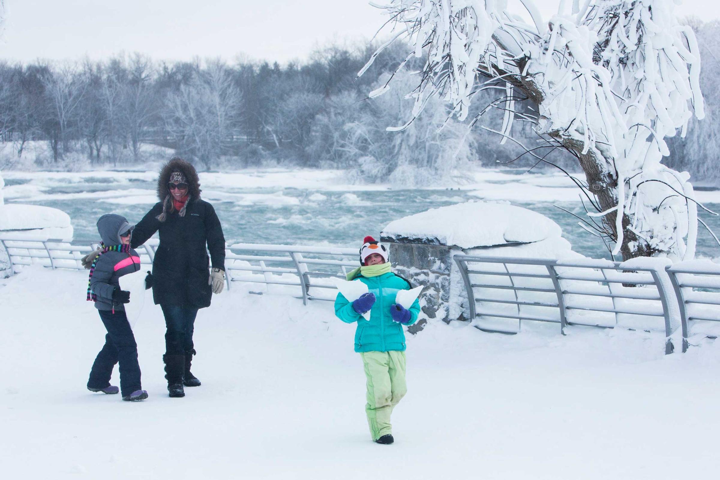 A family walks through the snow near the frozen Niagara Falls in Niagara Falls, Feb. 17, 2015.