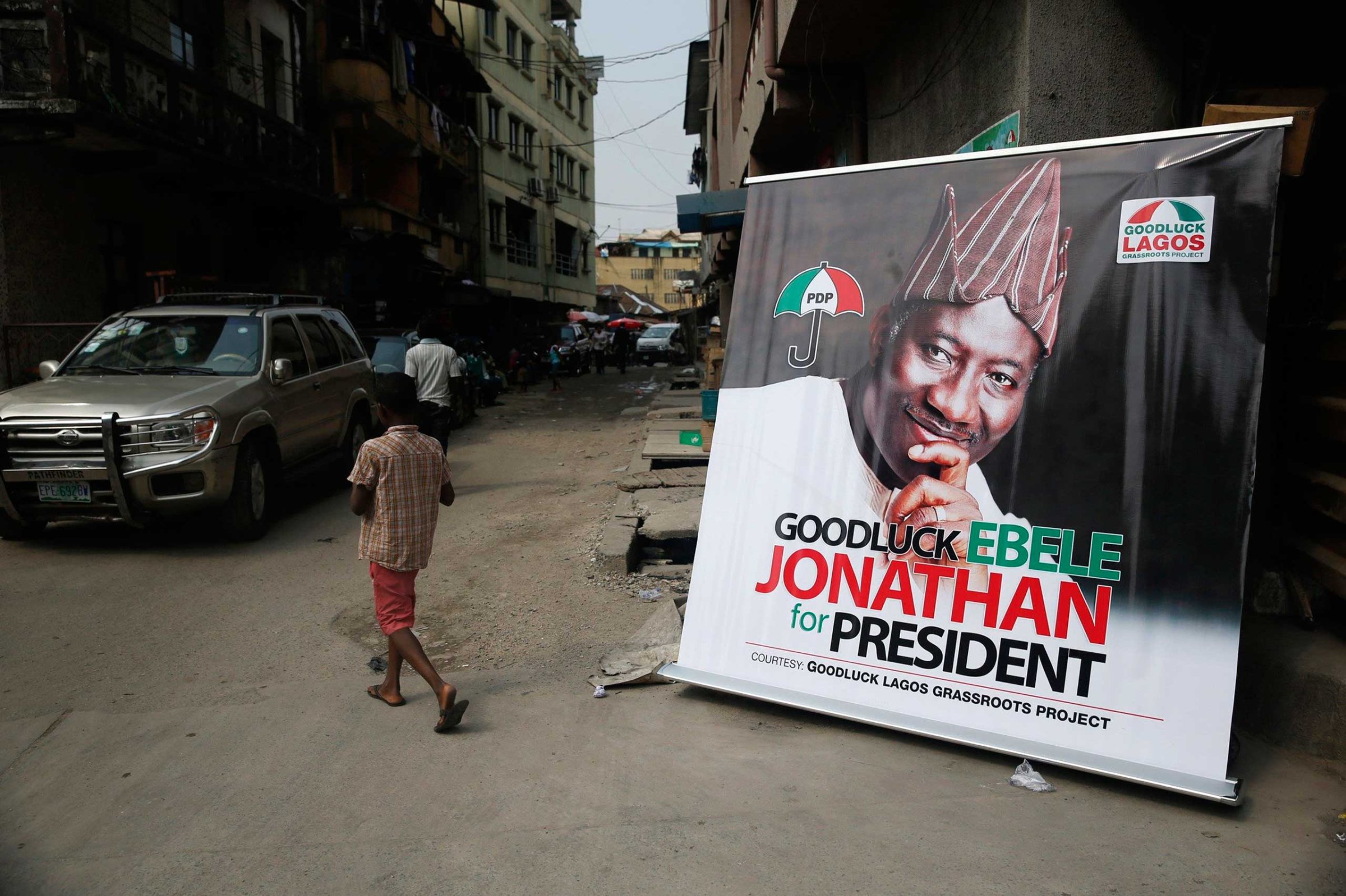 A boy walks near a banner campaigning for Nigeria's President Goodluck Jonathan along a street at Campus Square neighborhood in Lagos, Feb. 2, 2015.