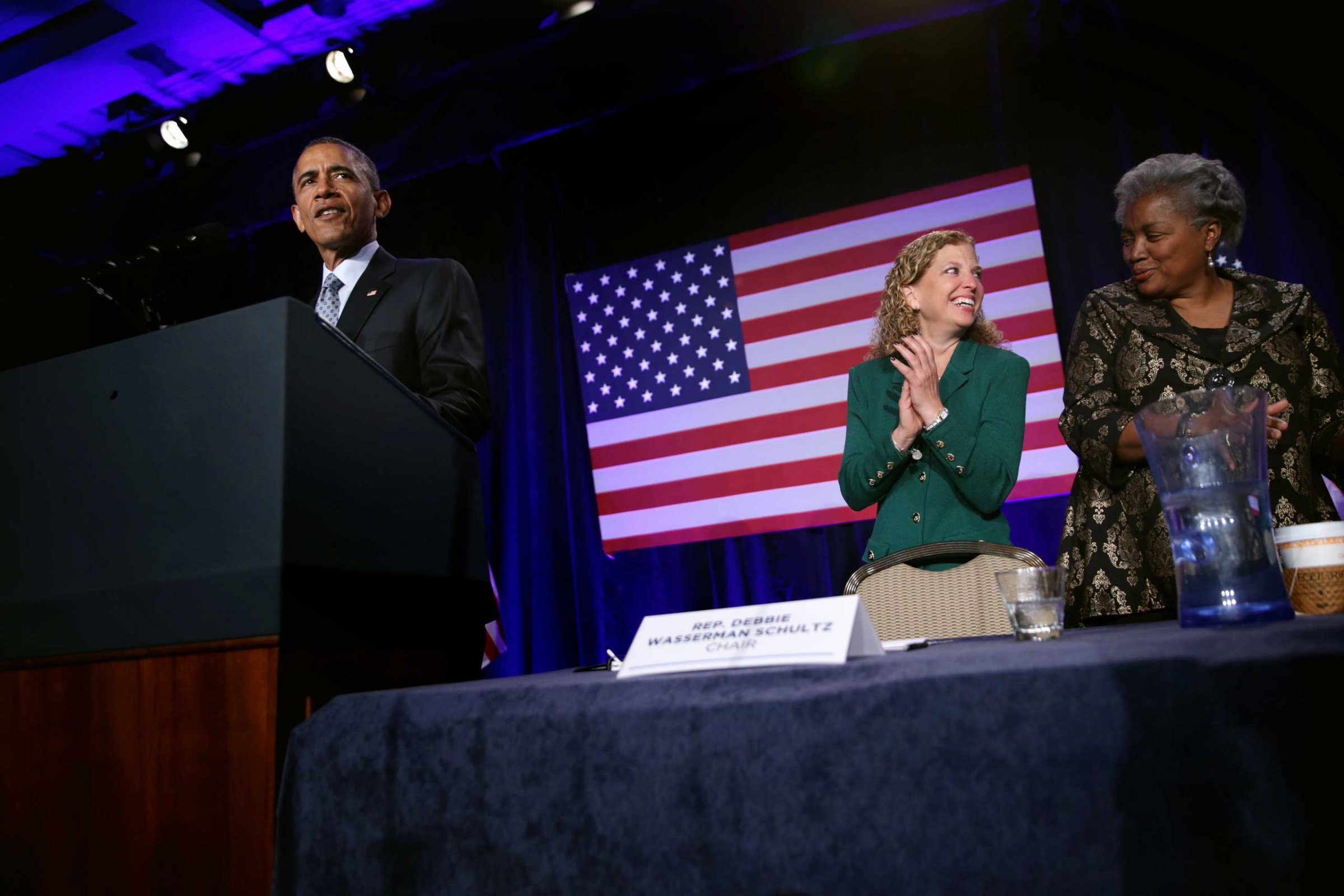 President Obama speaks as Democratic National Committee Chair and Rep. Debbie Wasserman Schultz and Vice Chair for Voter Registration and Participation Donna Brazile share a moment during the General Session of the 2015 DNC Winter Meeting, Feb. 20, 2015 in Washington, DC.