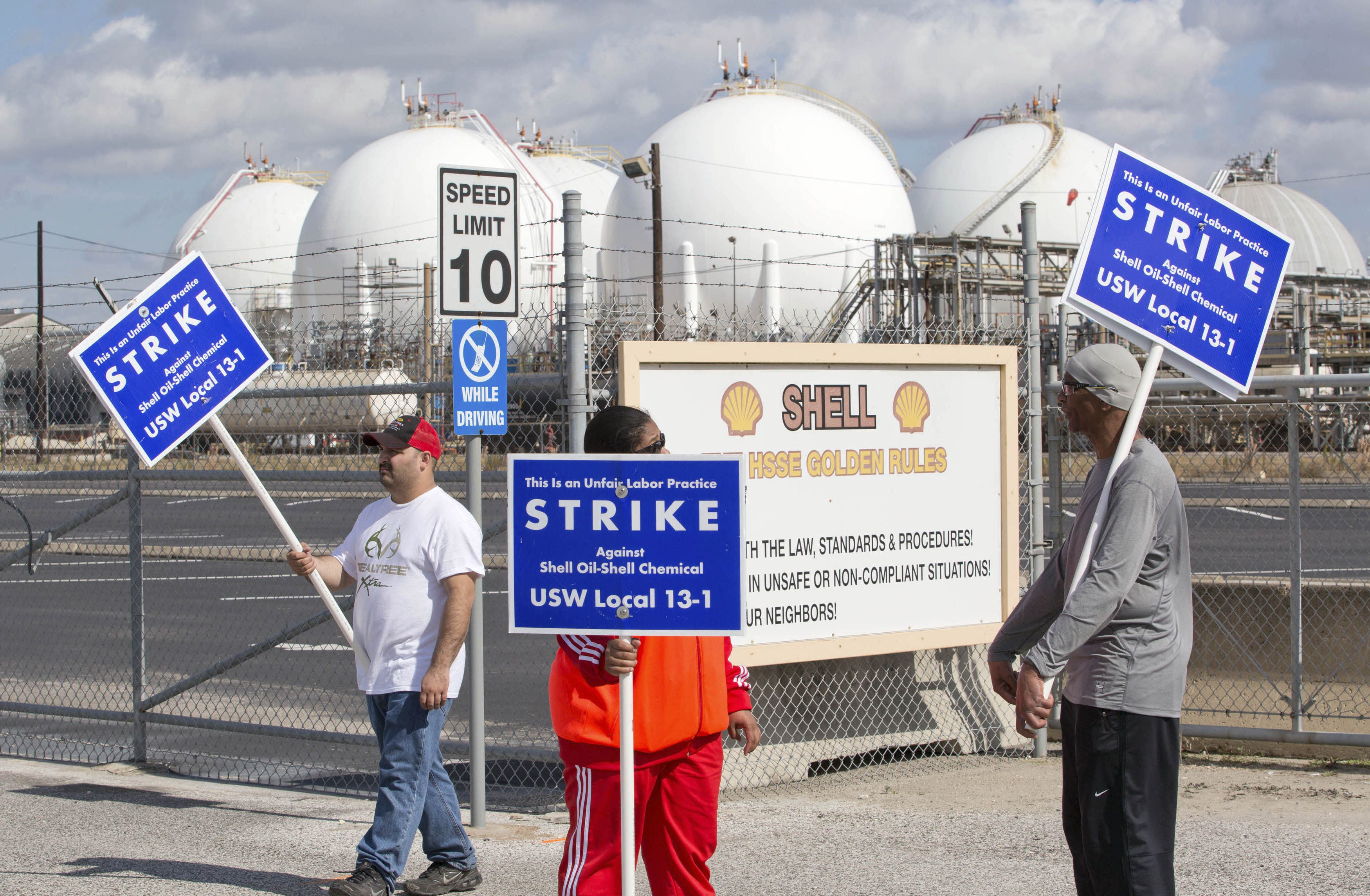 Workers from the USW union walk a picket line outside the Shell Oil Deer Park Refinery in Deer Park, Texas