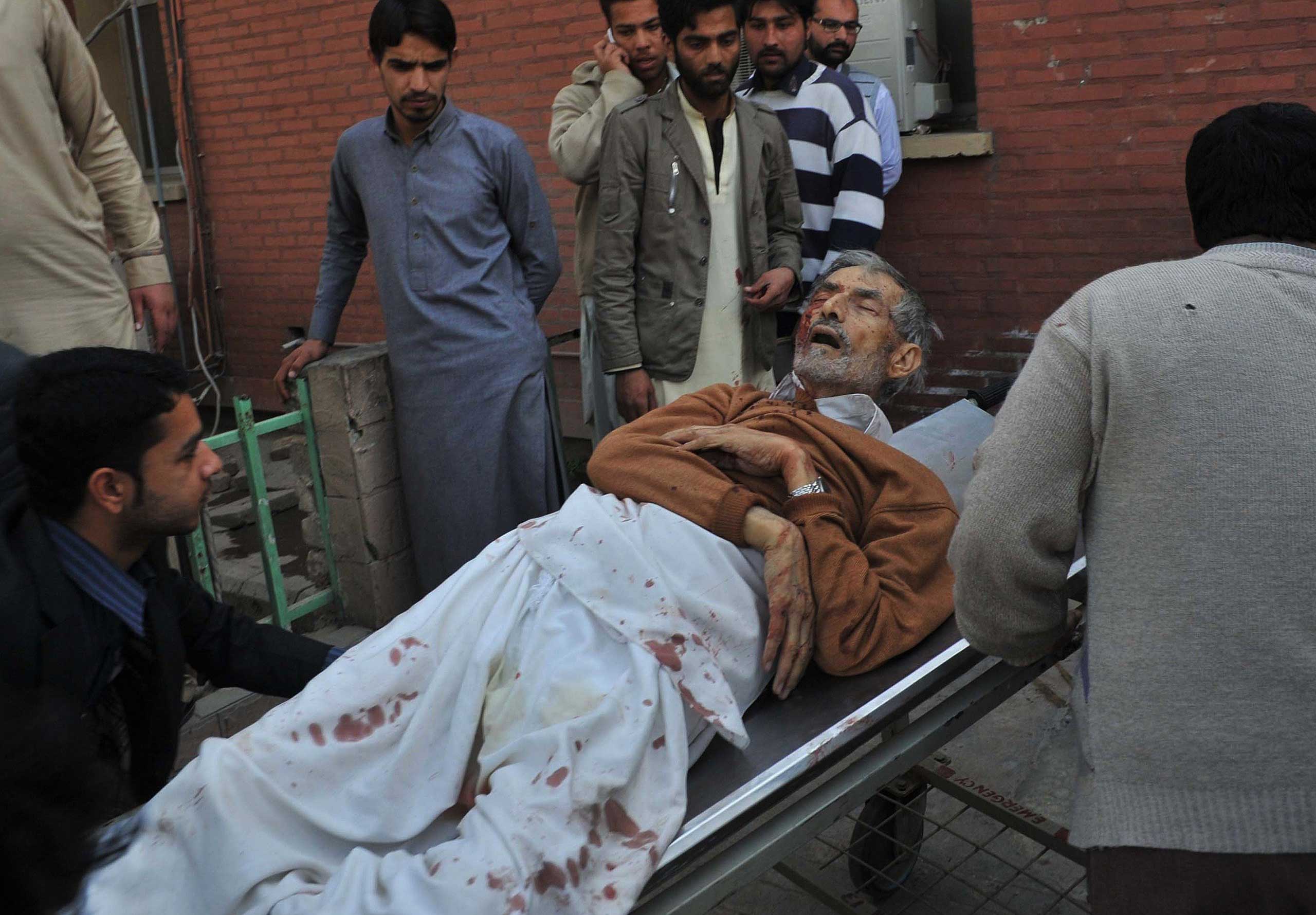 Pakistani residents move an injured worshipper to a hospital following an attack by Taliban militants on a Shi'ite Muslim mosque in Peshawar on Feb. 13, 2015.