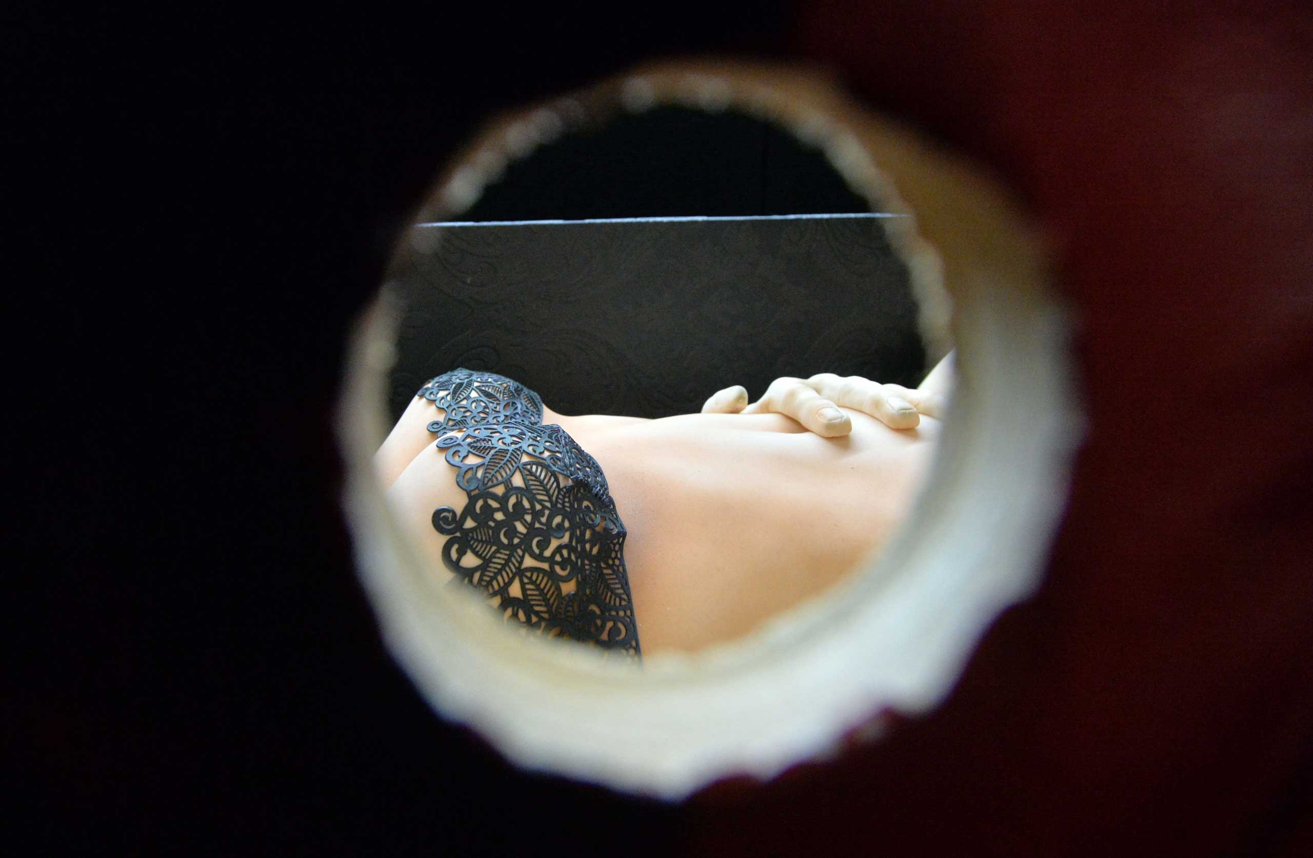 Feb. 8, 2015. A cake model of a women is seen through a peephole in an exhibit depicting the book and film, Fifty Shades of Grey, during the final day of the Cake International show in Manchester, northwest England.